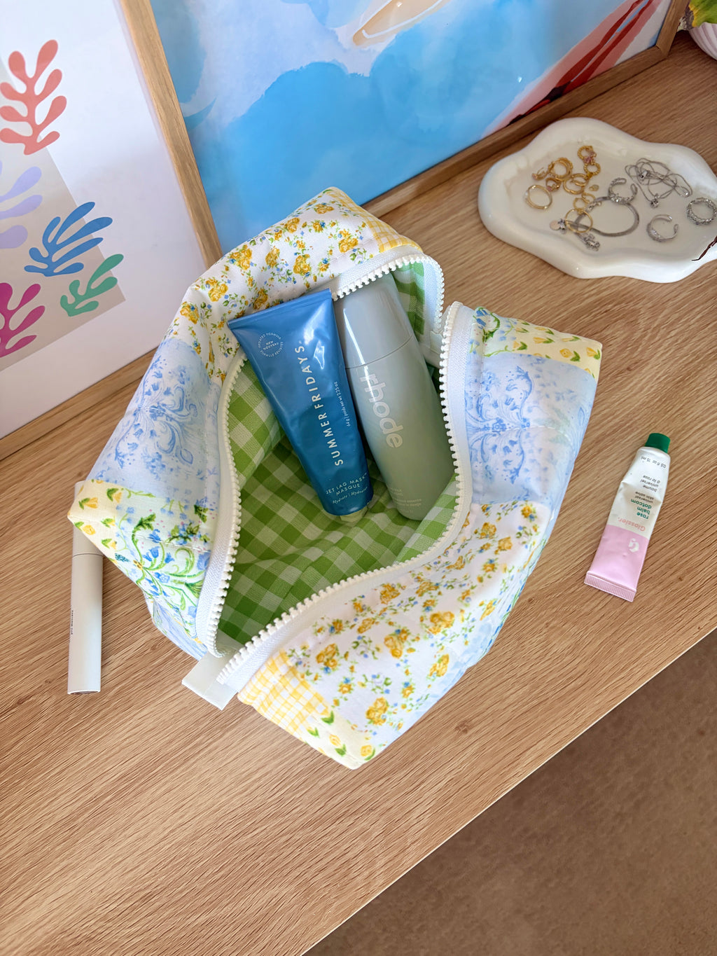 Large patchwork makeup bag opened with toiletries inside, blue floral and green gingham