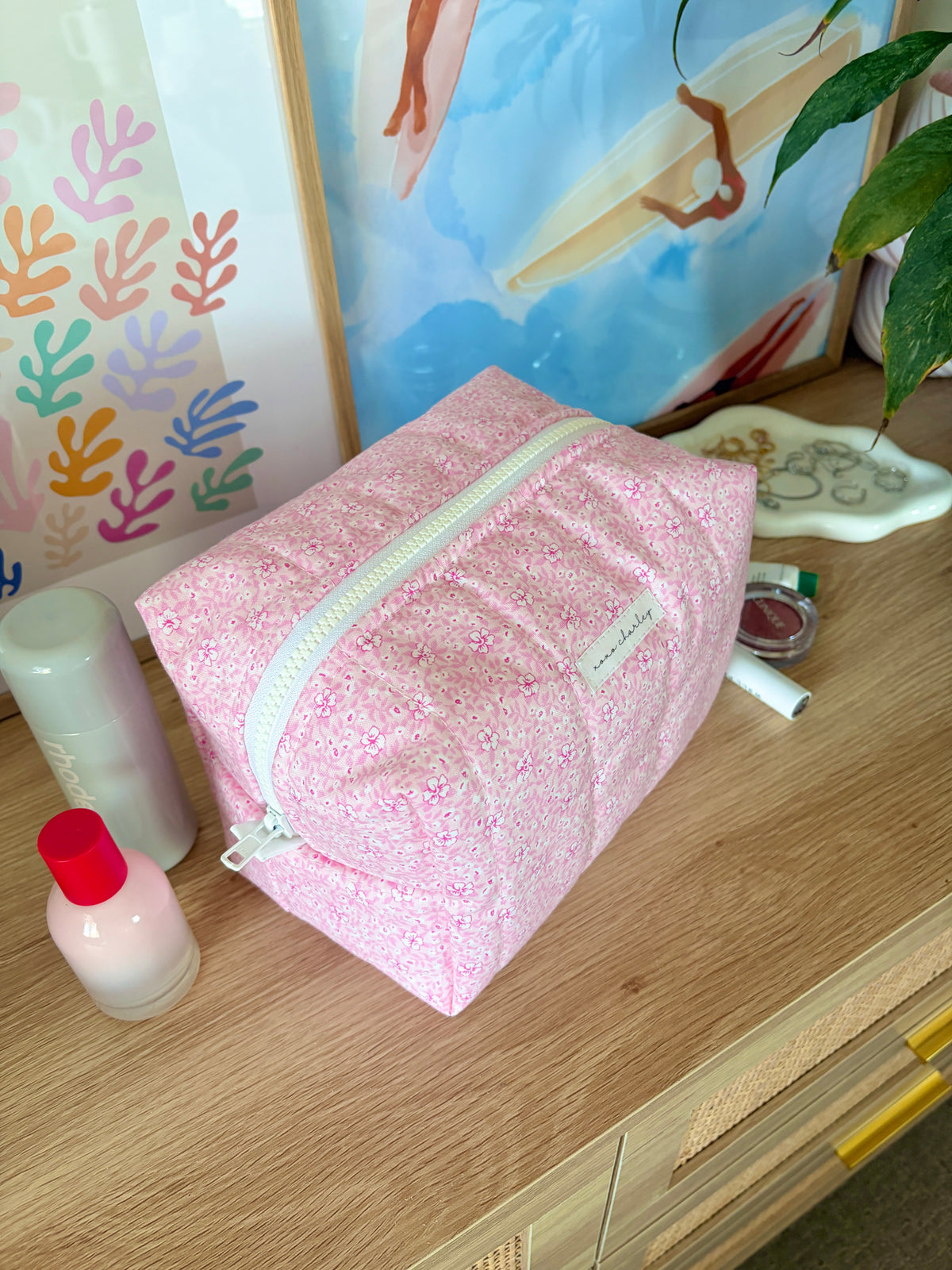 Pink glitter makeup bag with mint zipper trim and top zipper closure.