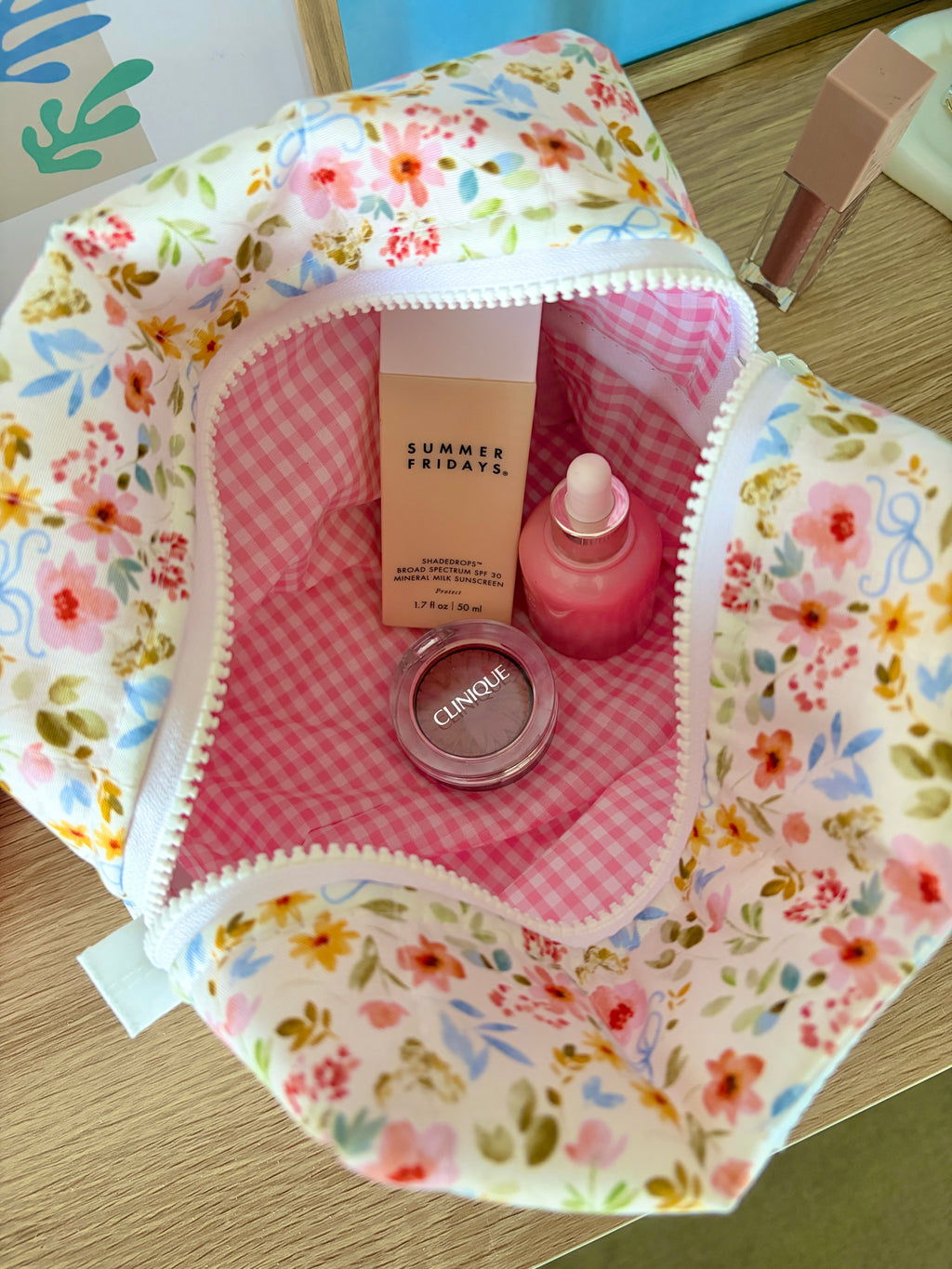 Floral large makeup bag open to reveal pink gingham lining and multicolor floral exterior