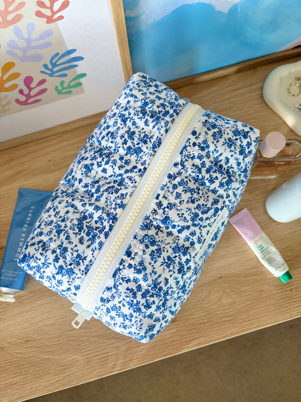 Large blue floral makeup bag, standing on counter with zip front