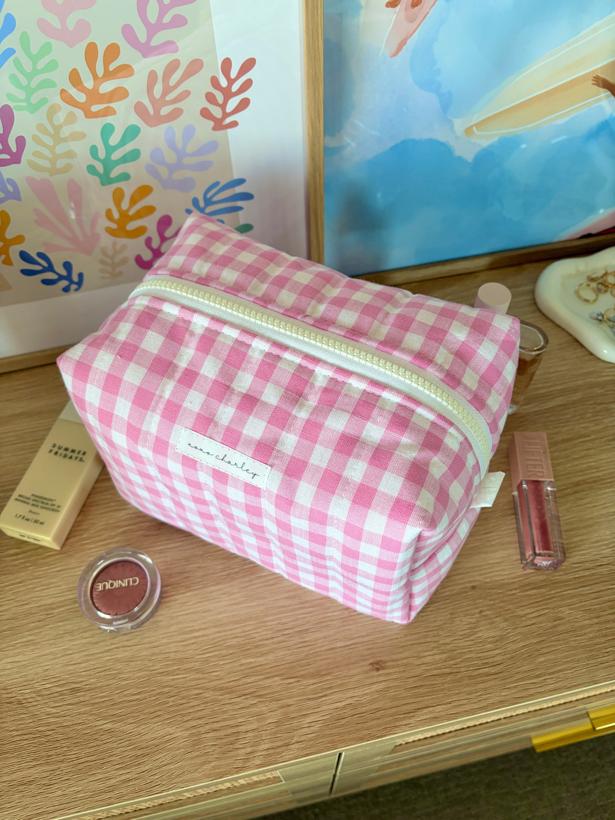 Pink gingham large makeup bag with white zipper, side-on view of the bag front
