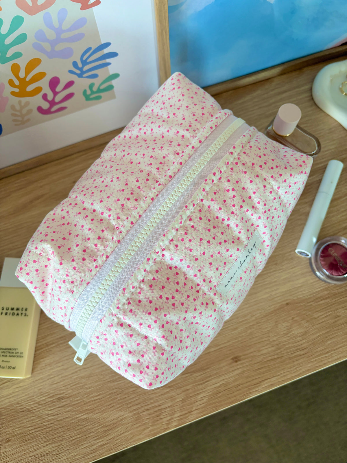 Large pink makeup bag with tiny heart print, light blue zipper trim