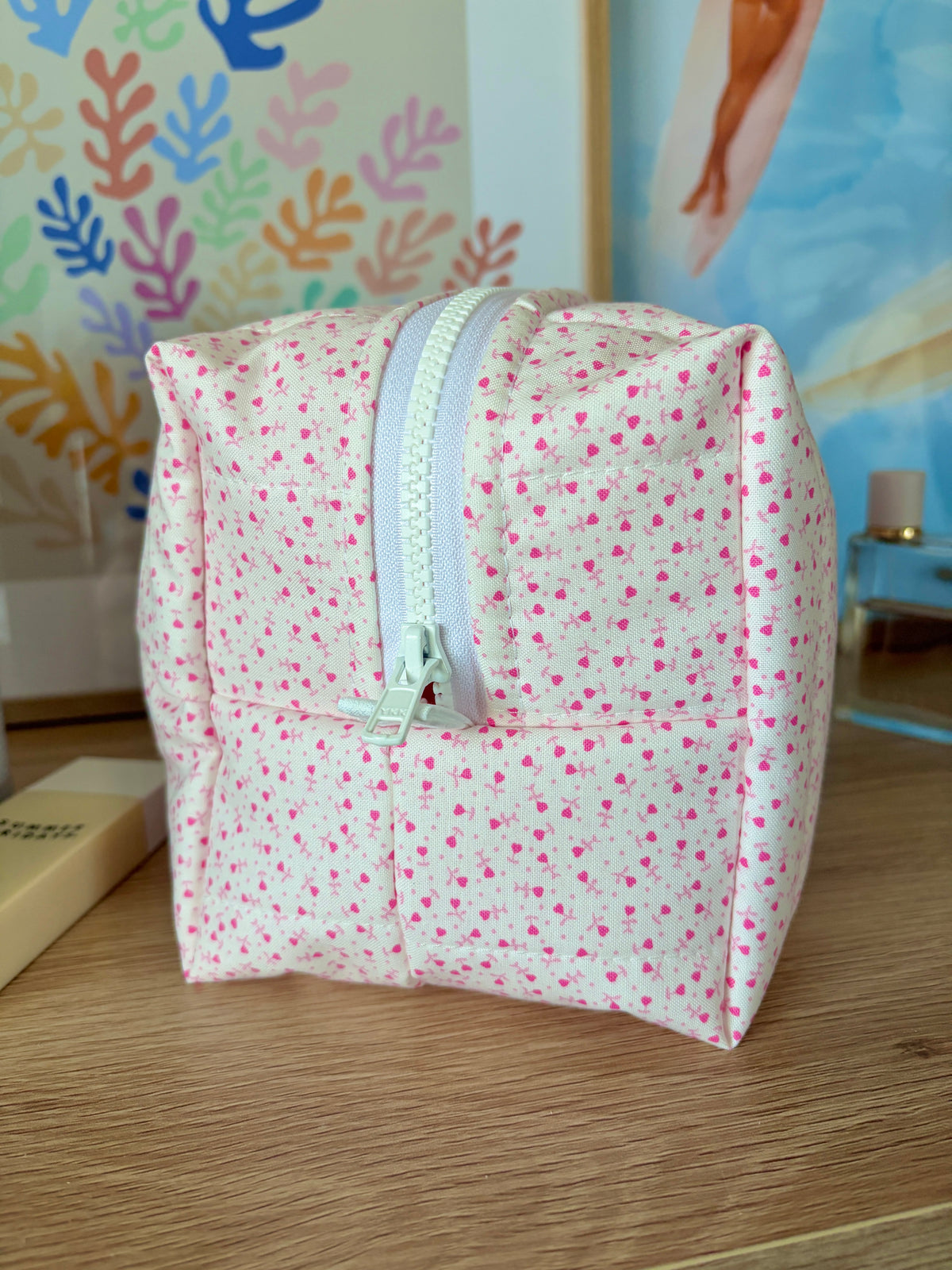 Large pink makeup bag with tiny heart print, curved corners, zipper closure