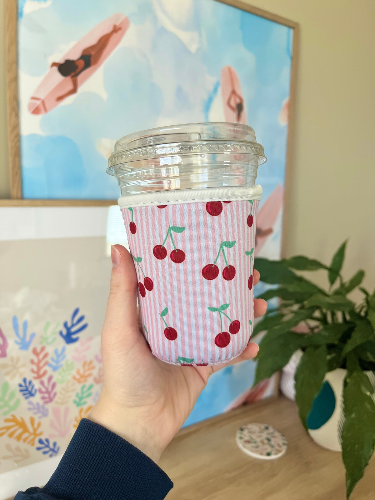 Pink cup sleeve with vertical stripes and red cherries, fits small takeout cup