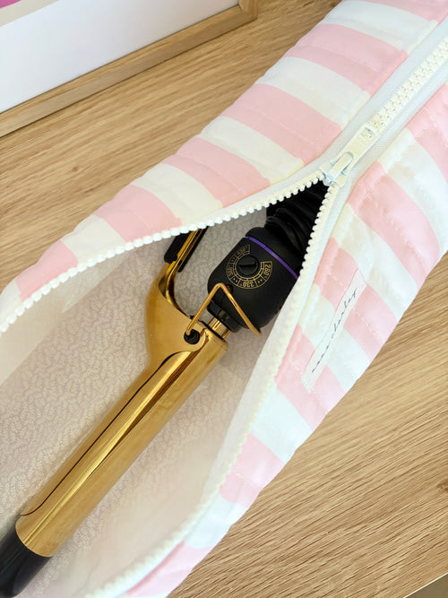 Pink and white striped hair tools bag with zipper open, showing gold tool clips