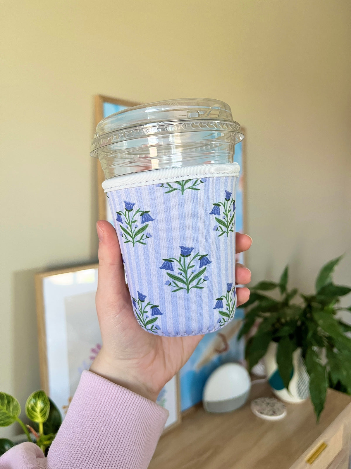 Small cup sleeve with light-blue vertical stripes and blue flower stems