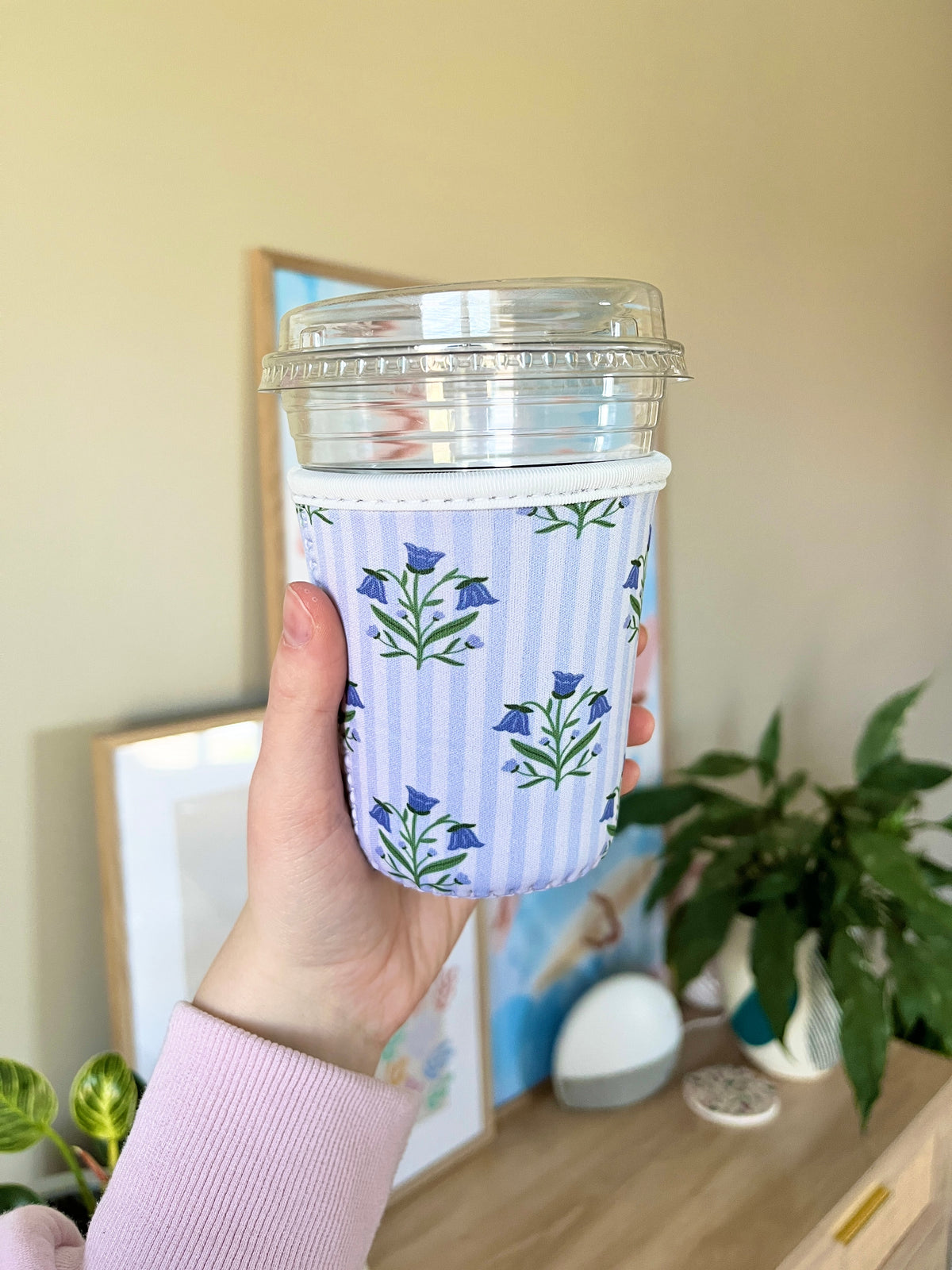 Small cup sleeve with blue floral print on light striped fabric