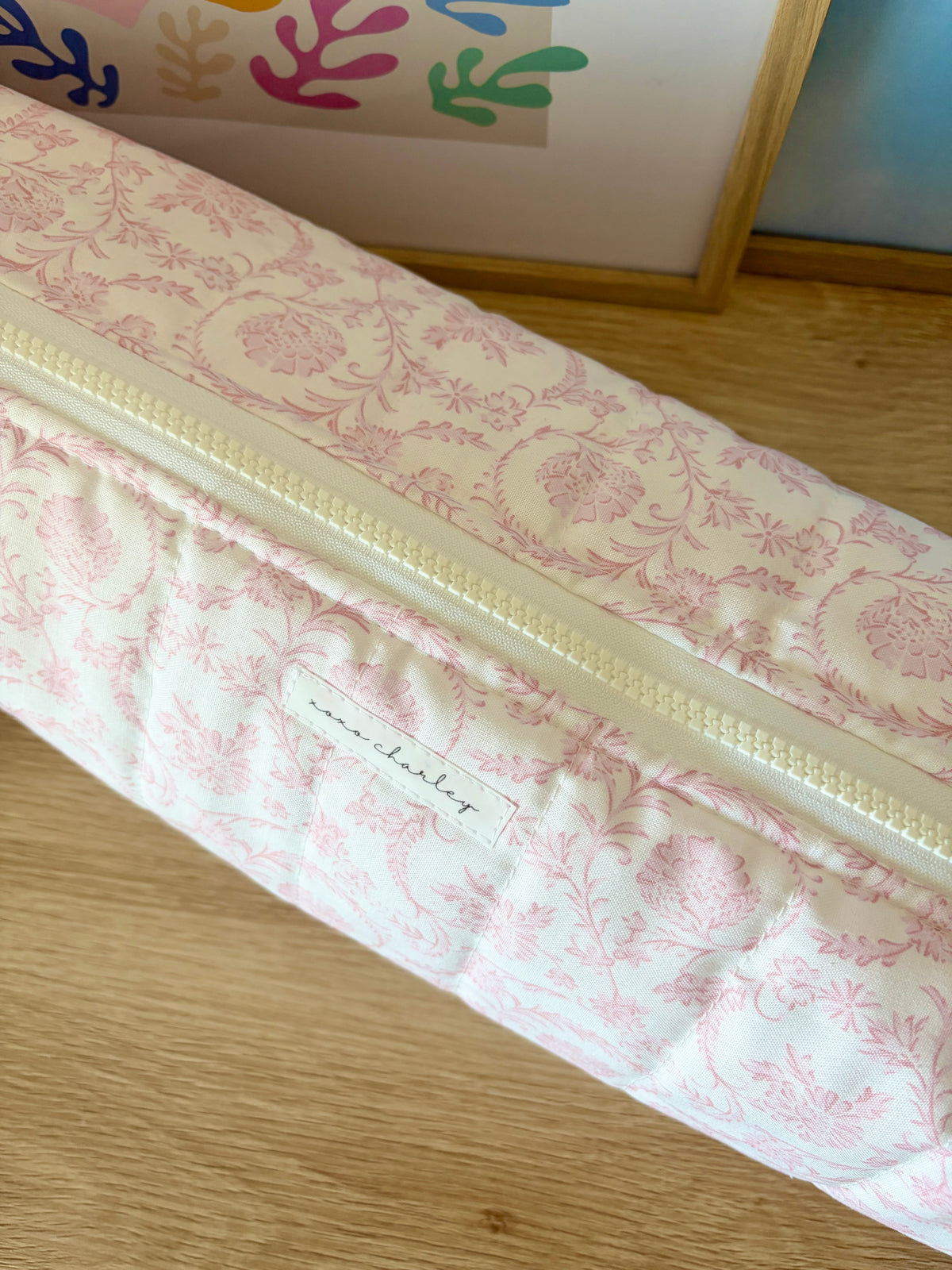 Pink and white floral hair tools bag, close-up along the zipper.