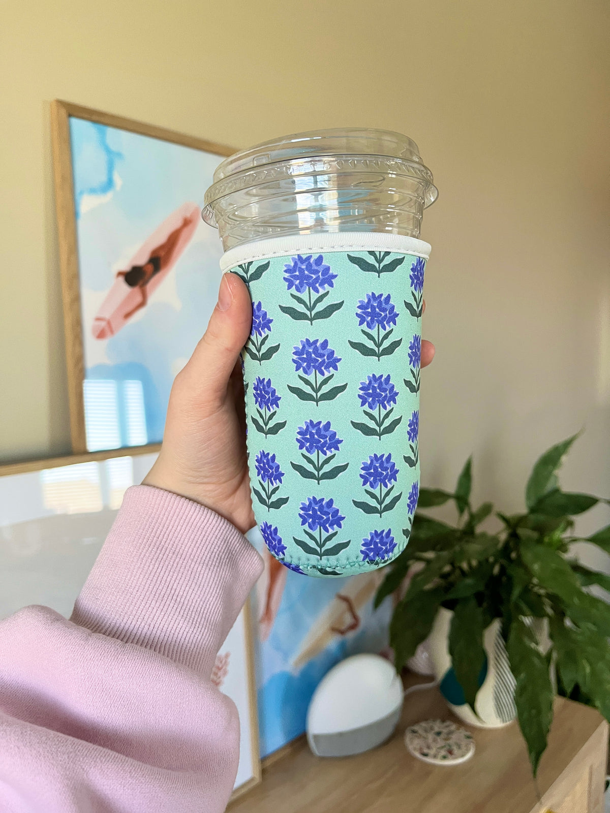 Light green cup sleeve with purple wildflower pattern and clear lid opening