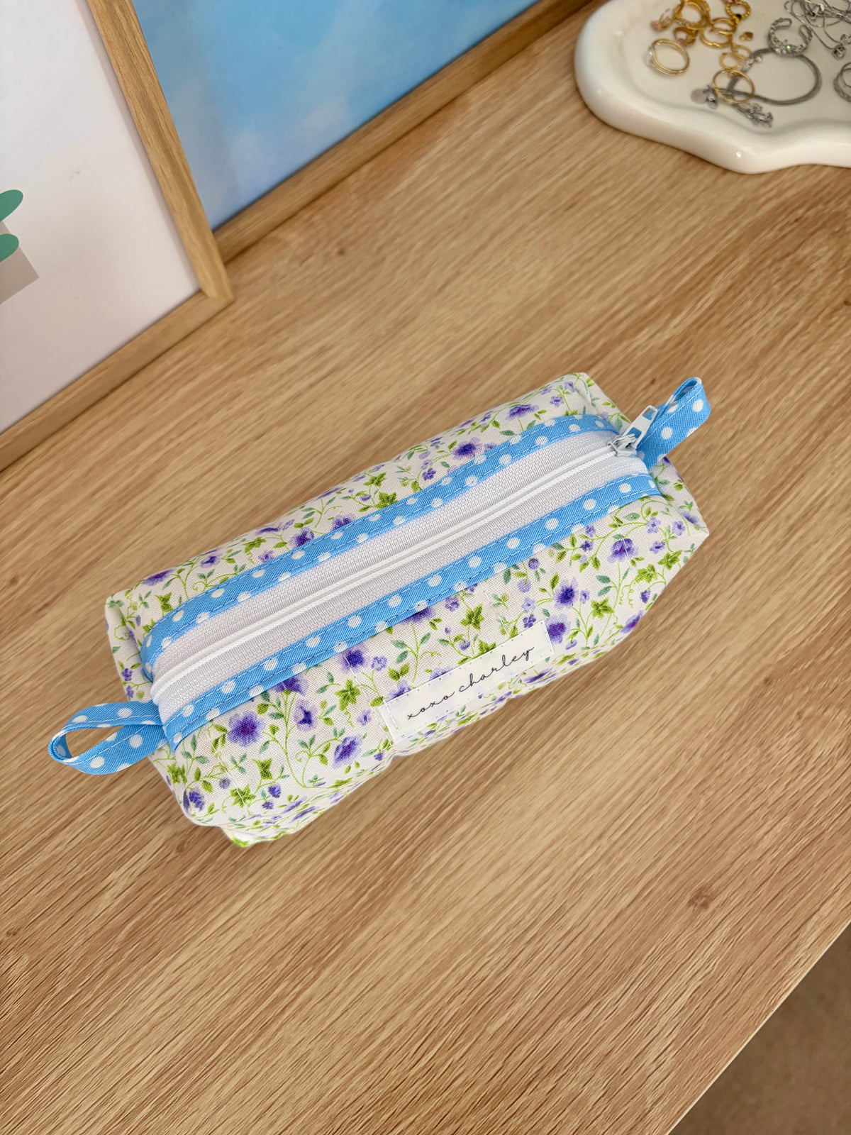 Floral fabric bag pouch with blue stripe zipper and matching ribbon tie