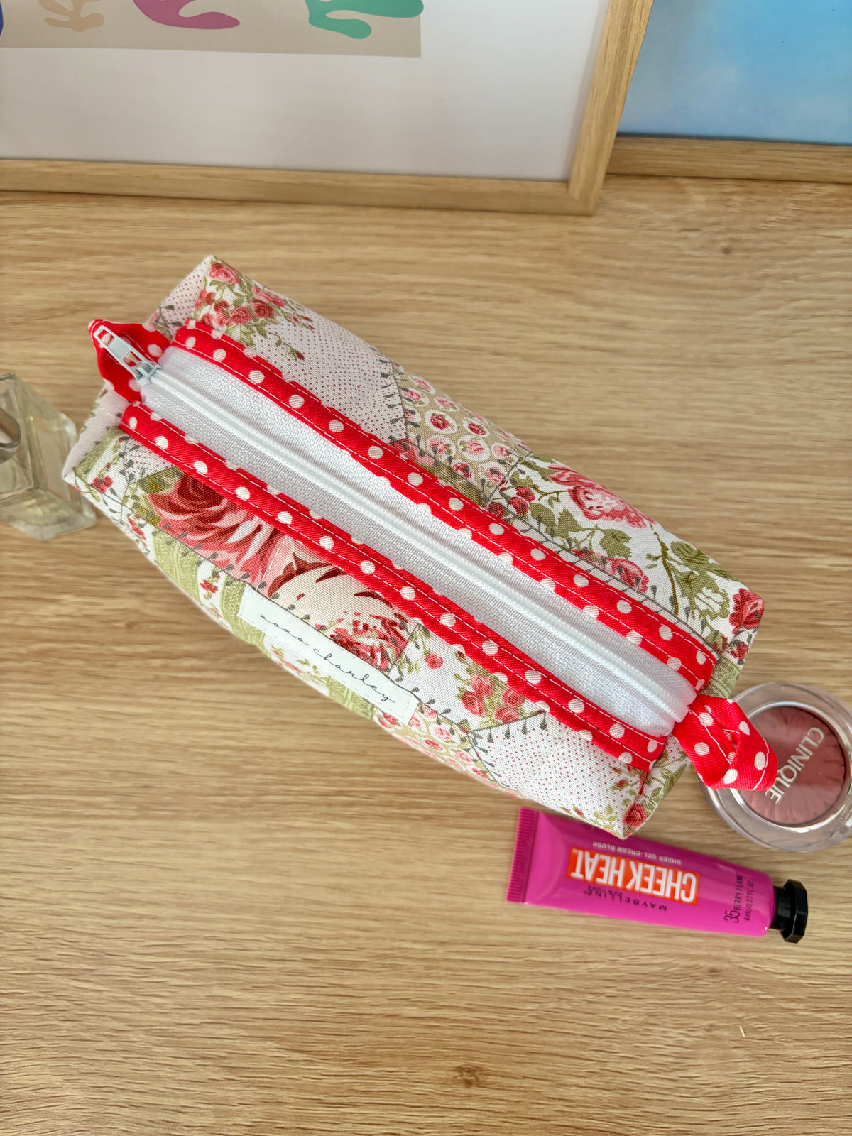 Colorblock fabric bag with red dotted handles and patchwork floral design, top zip