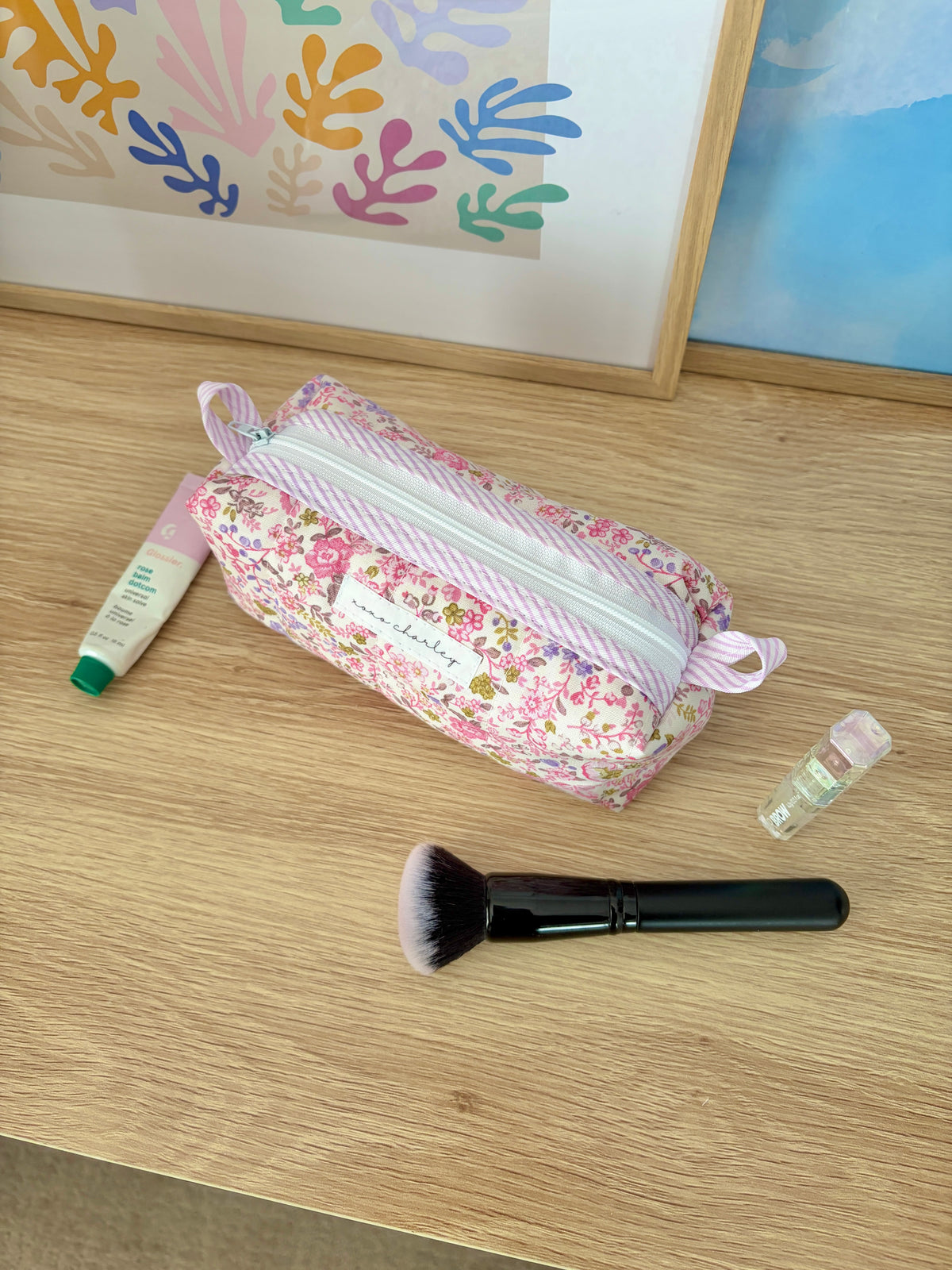 Pink floral colorblock makeup bag with light blue striped zipper and bow handles