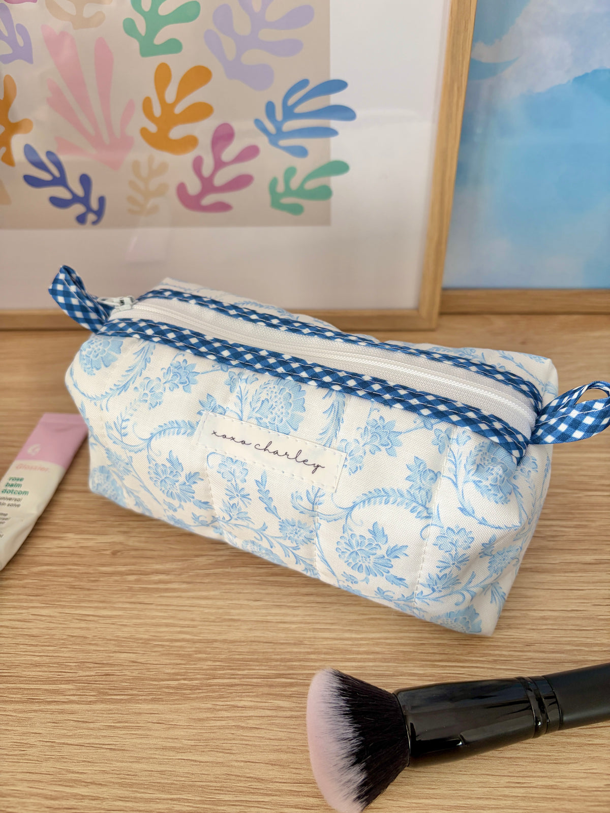 Blue and white floral cosmetic bag with gingham trim and wrist loop
