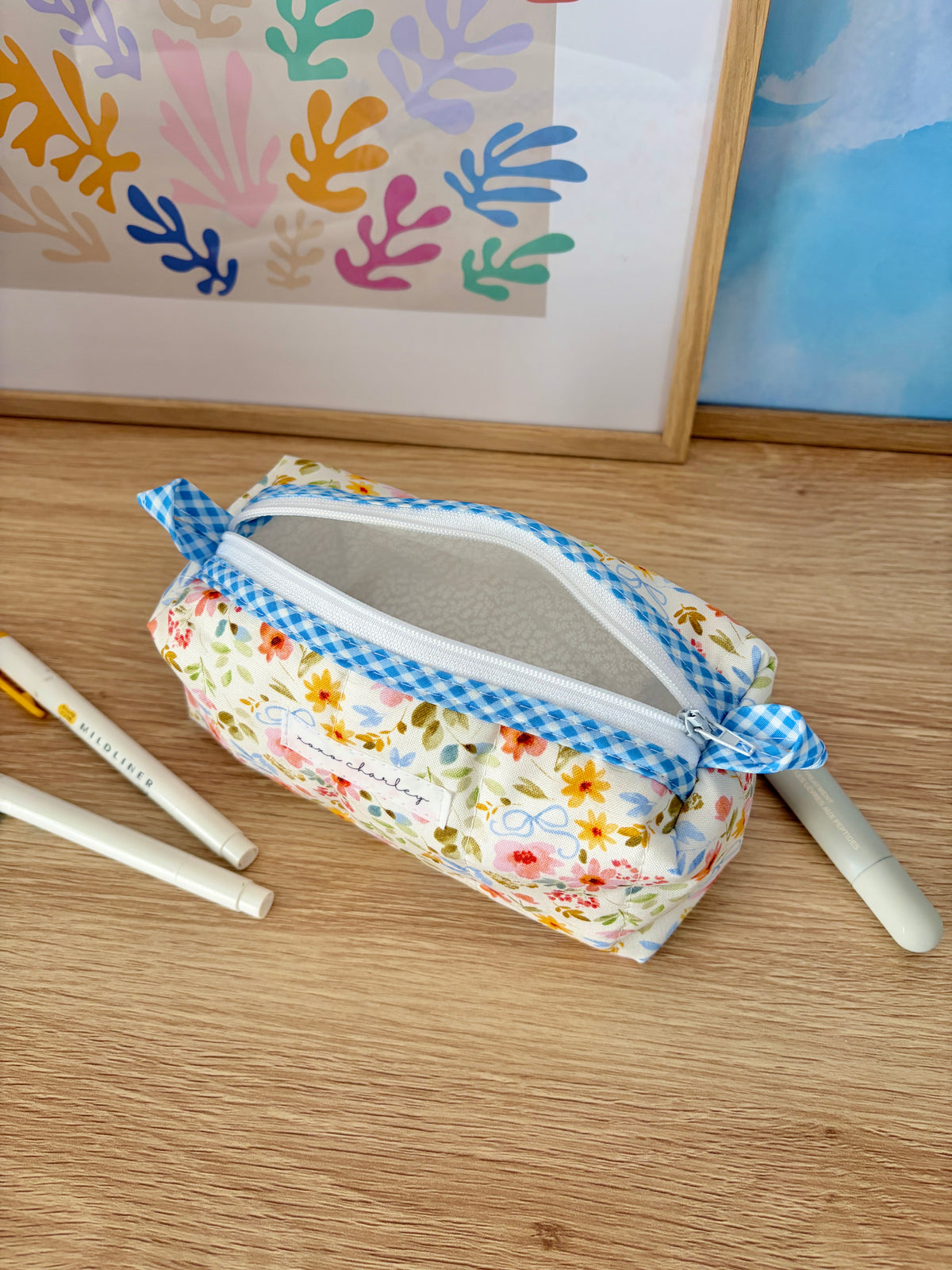 Floral colorblock zip pouch with blue gingham trim and visible gray interior