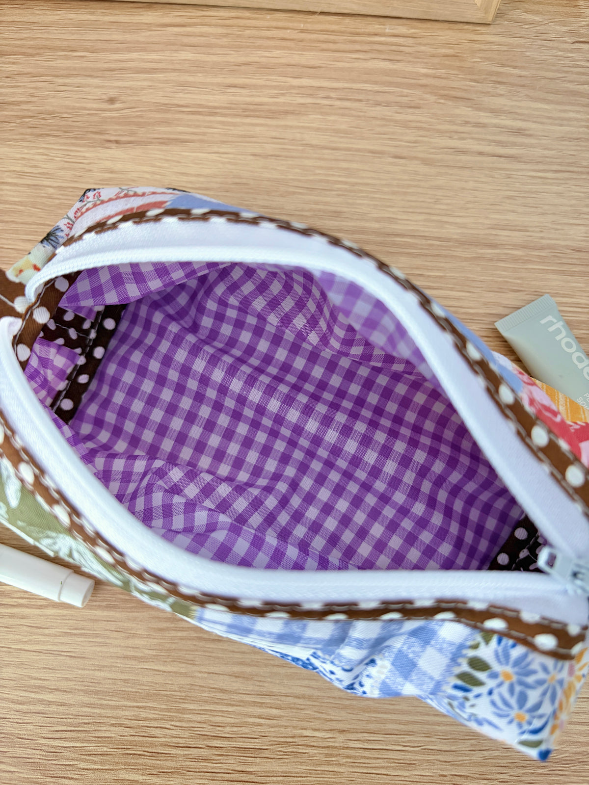 Open colorblock bag interior with purple gingham fabric and white zipper opening