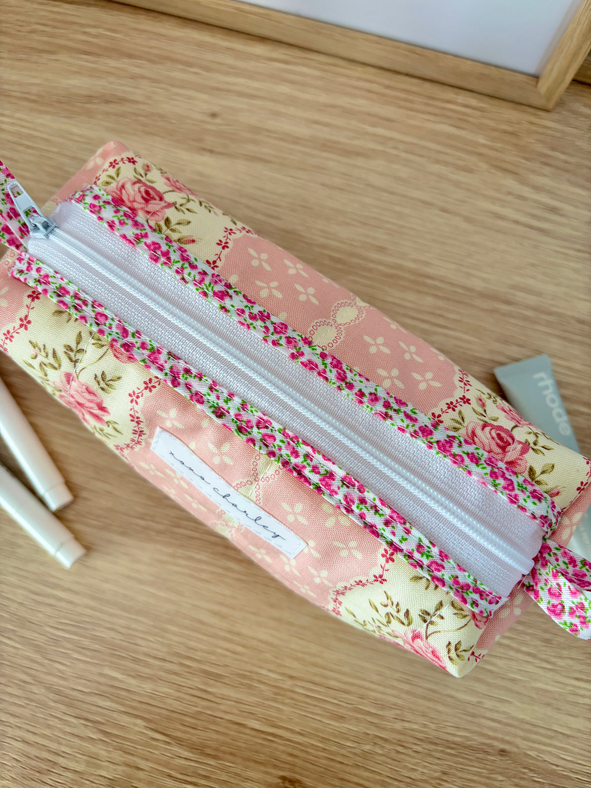 Floral colorblock zippered bag opened view, showing pink lining and colorful floral trim