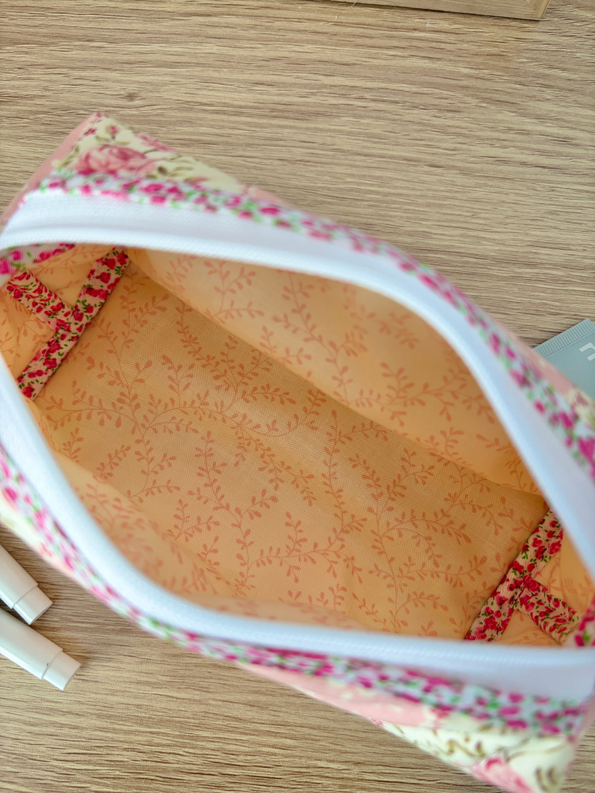 Floral colorblock zippered bag interior close-up with pink patterned lining and white zipper