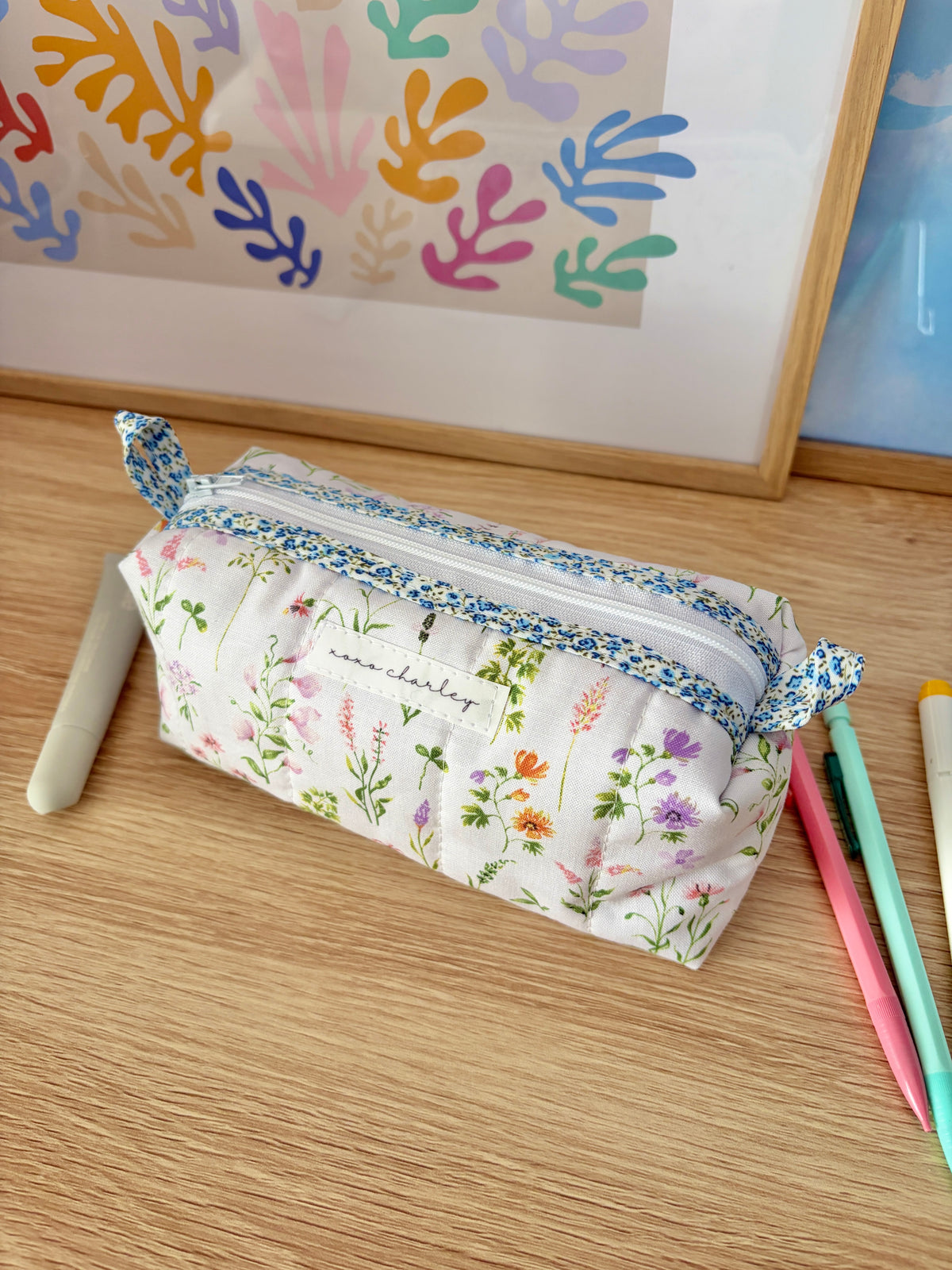 Floral zippered pouch bag with blue trim and multicolor wildflower print