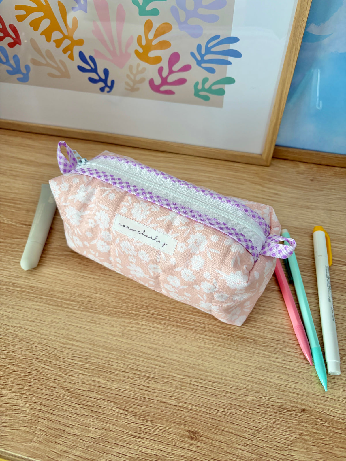 Floral fabric pouch bag with purple gingham trim and pastel peach base