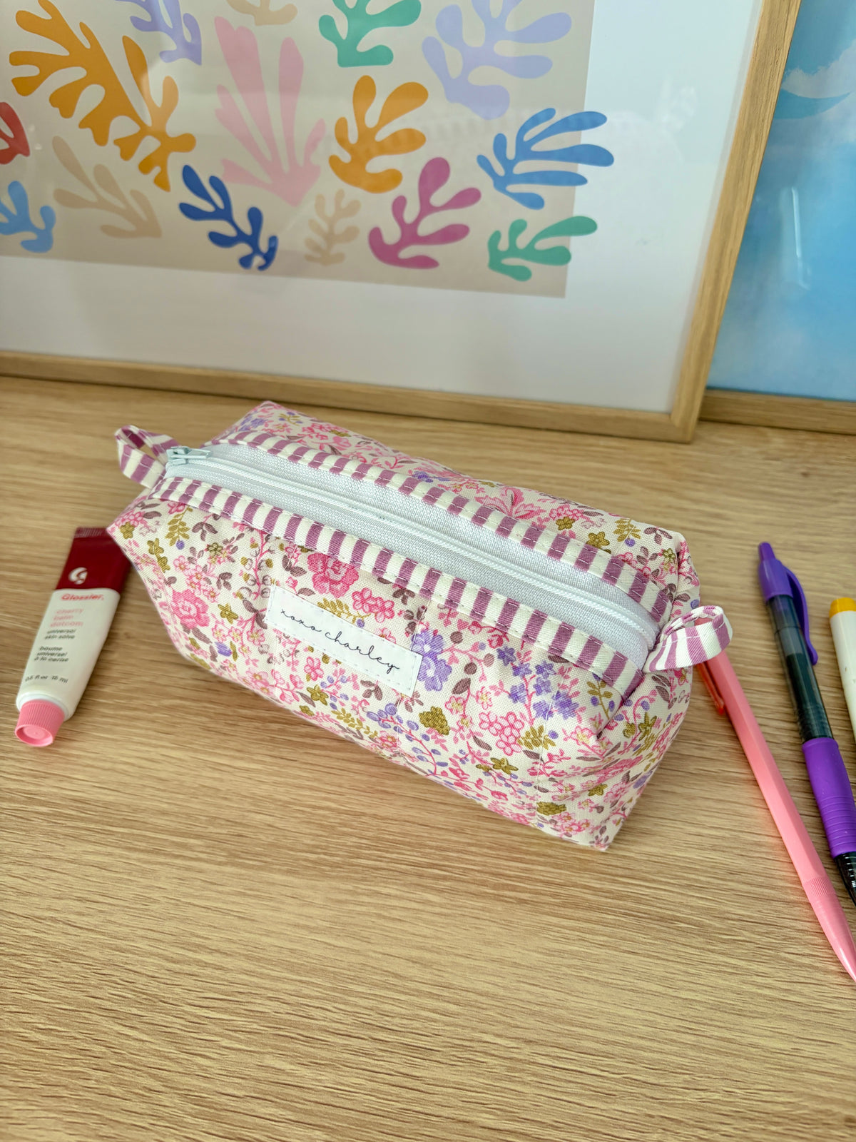 Floral zip pouch bag with pink and white striped trim, patterned exterior visible