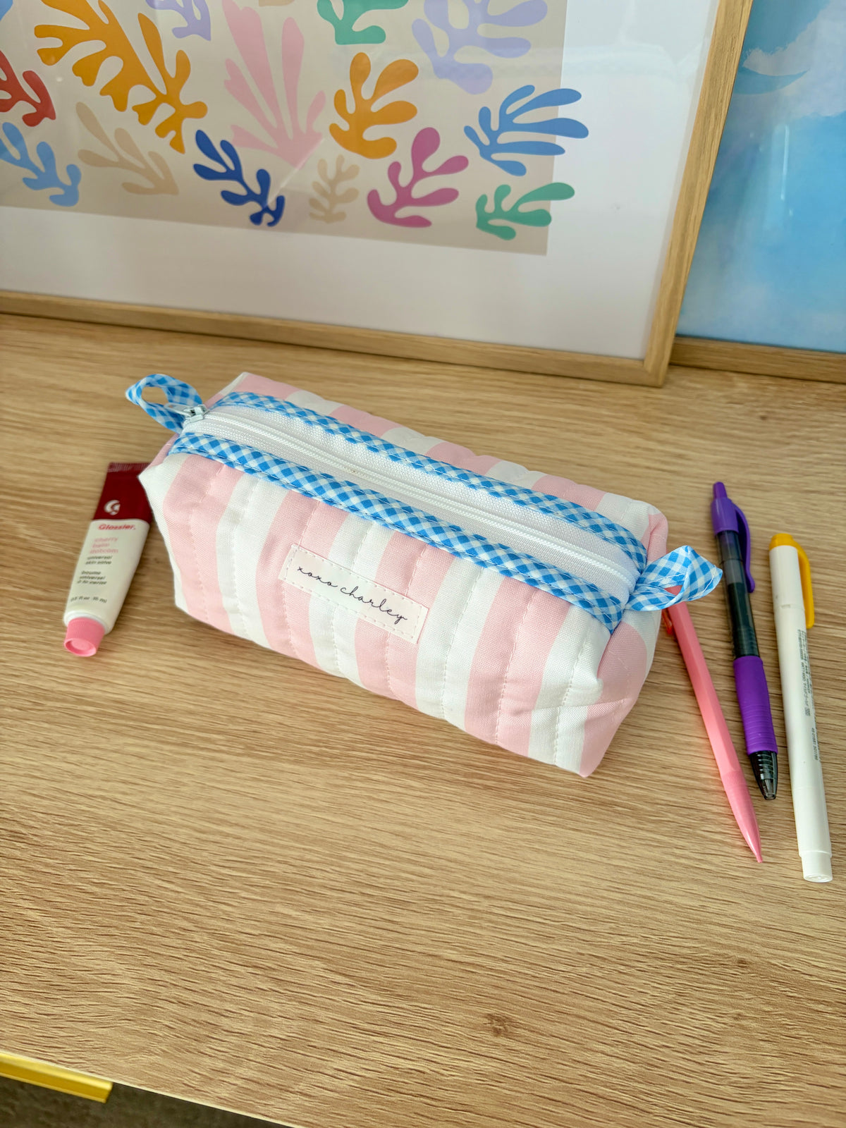 Striped pink-and-white cosmetic bag with blue gingham drawstring handle