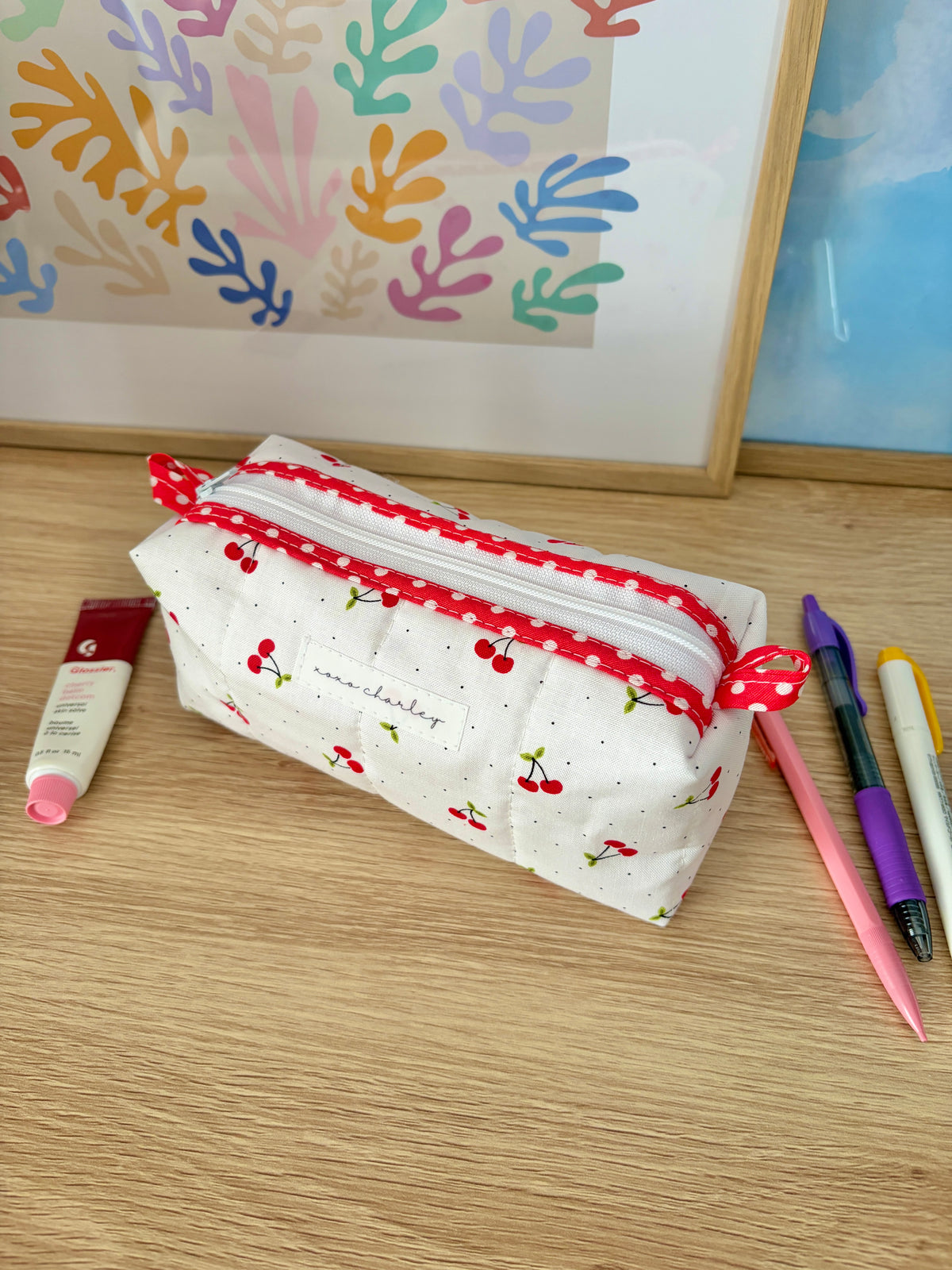 Cherry printed pouch bag with red zipper and red gingham lining, white exterior