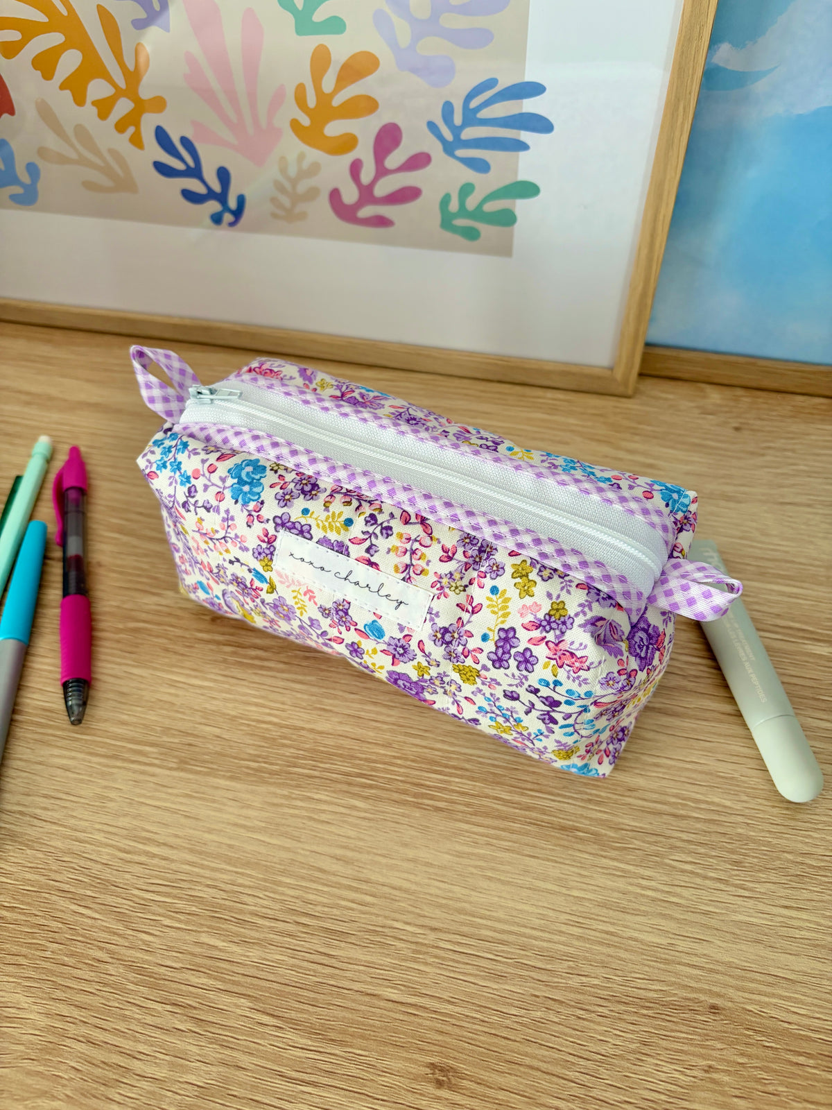 Purple ditsy floral zipper pouch bag with white trim and bow detail