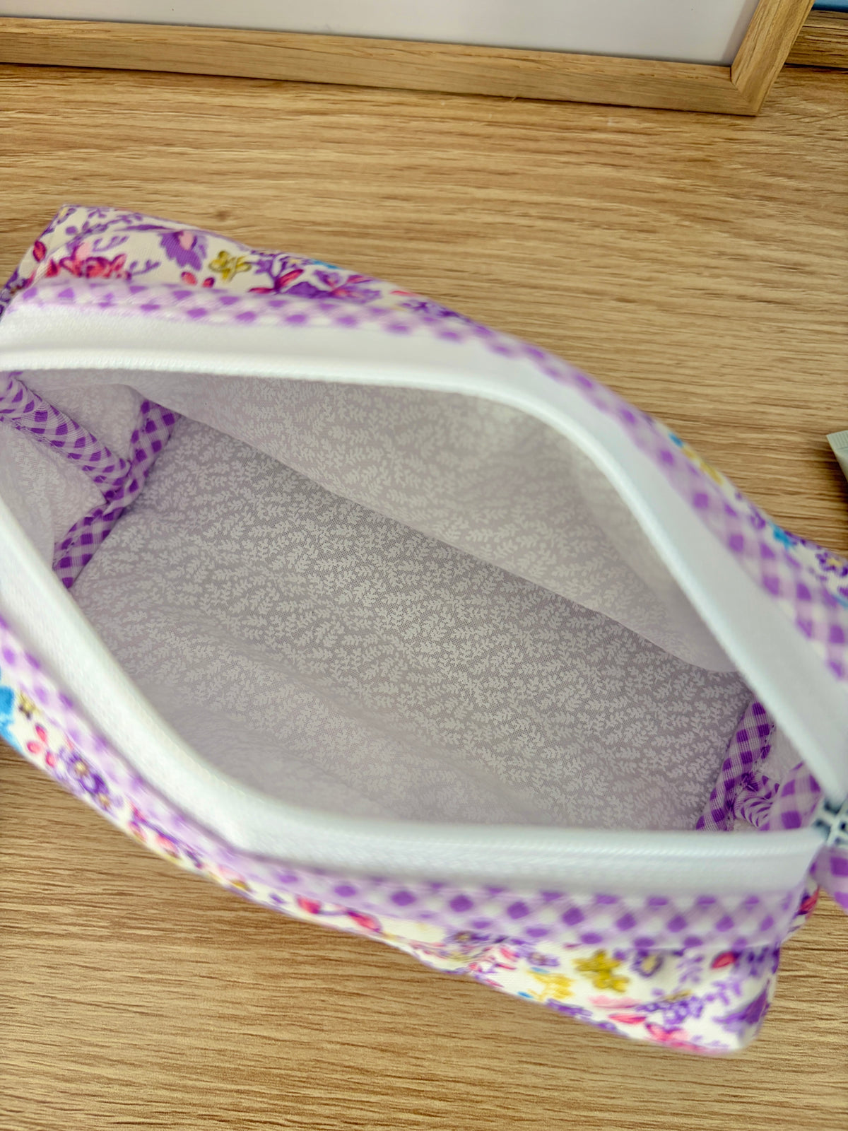 Close-up of interior of purple floral zipper pouch with gray patterned lining