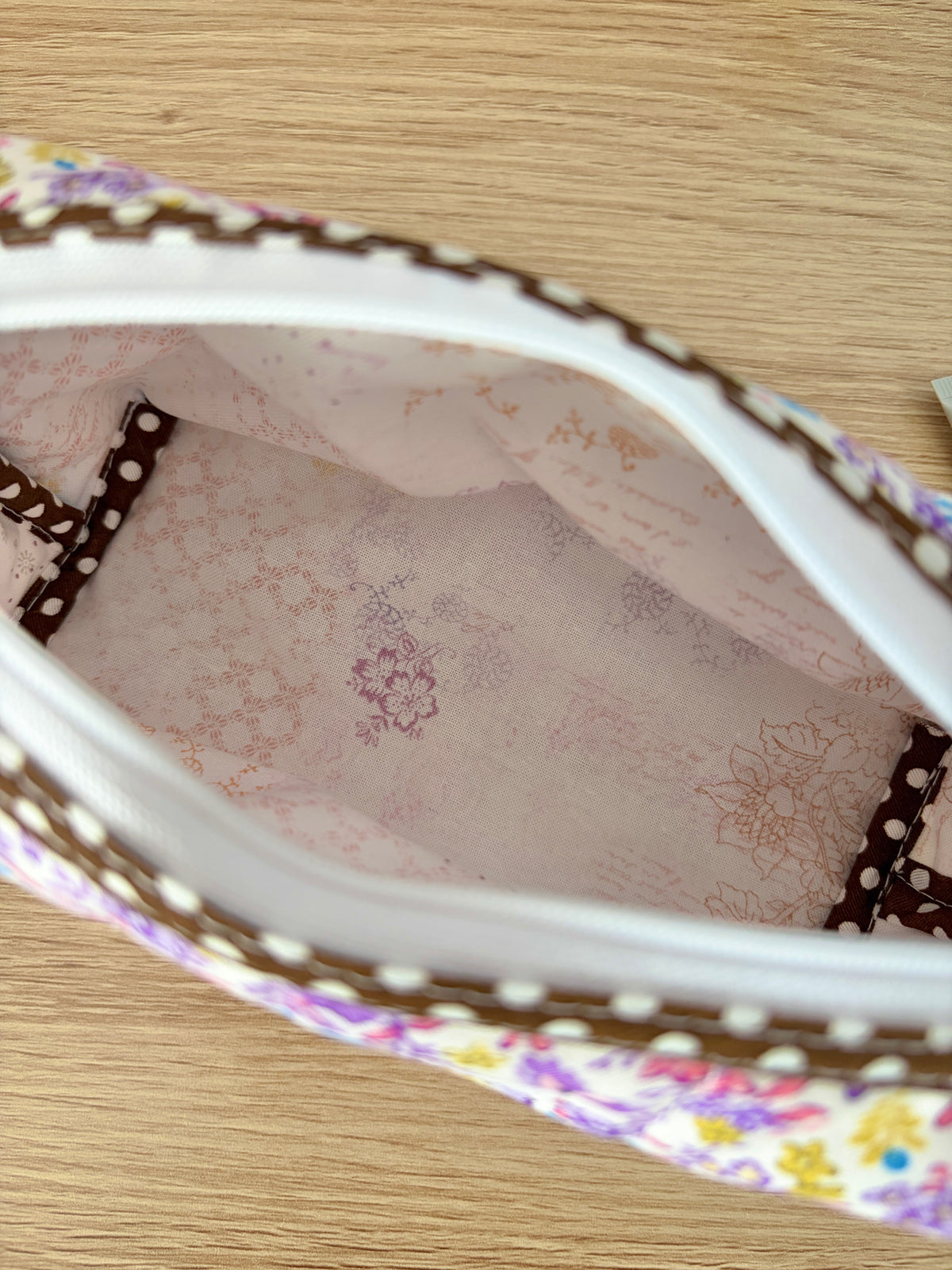 Purple floral zip pouch interior with pink patterned lining and zipper edge
