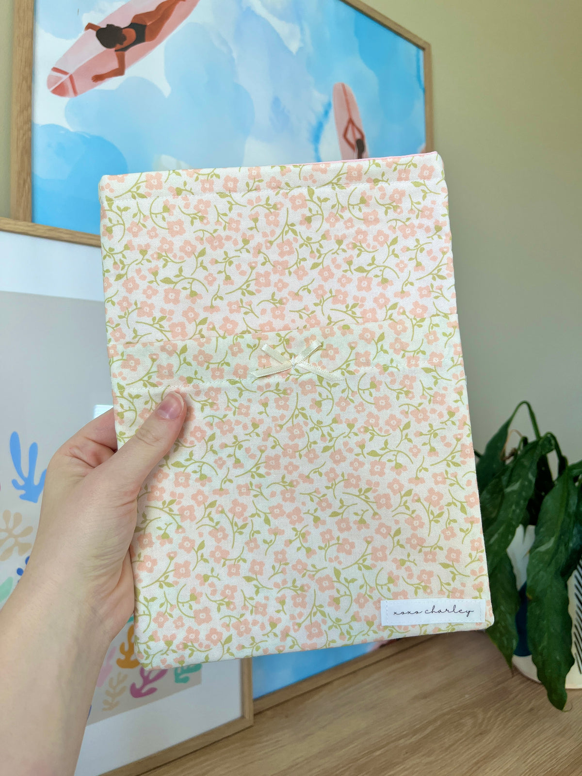 Floral medium book sleeve with front label pocket and pink accents, held up