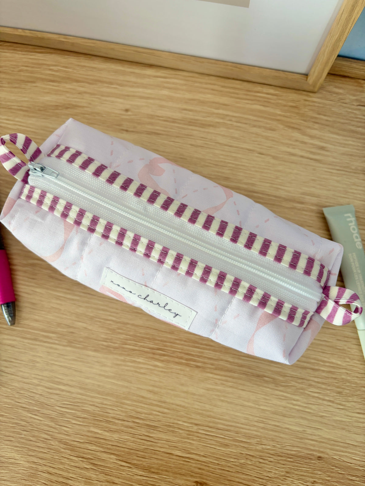 Large white floral zipper pouch with pink bow and purple striped zipper band