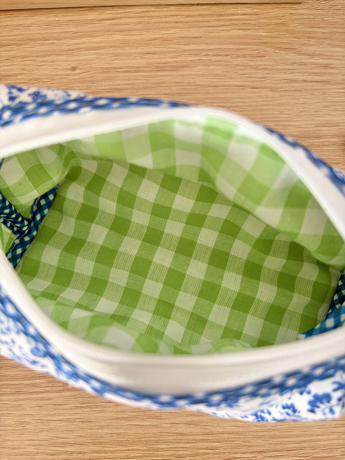 Open blue floral zip pouch showing green gingham lining inside