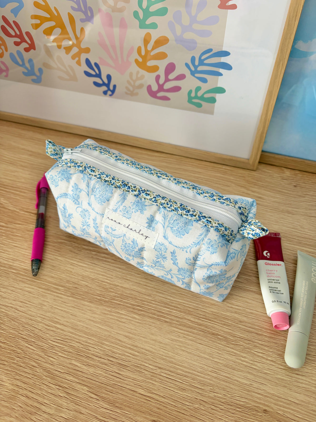 Zippered pouch bag with light blue floral fabric and white trim