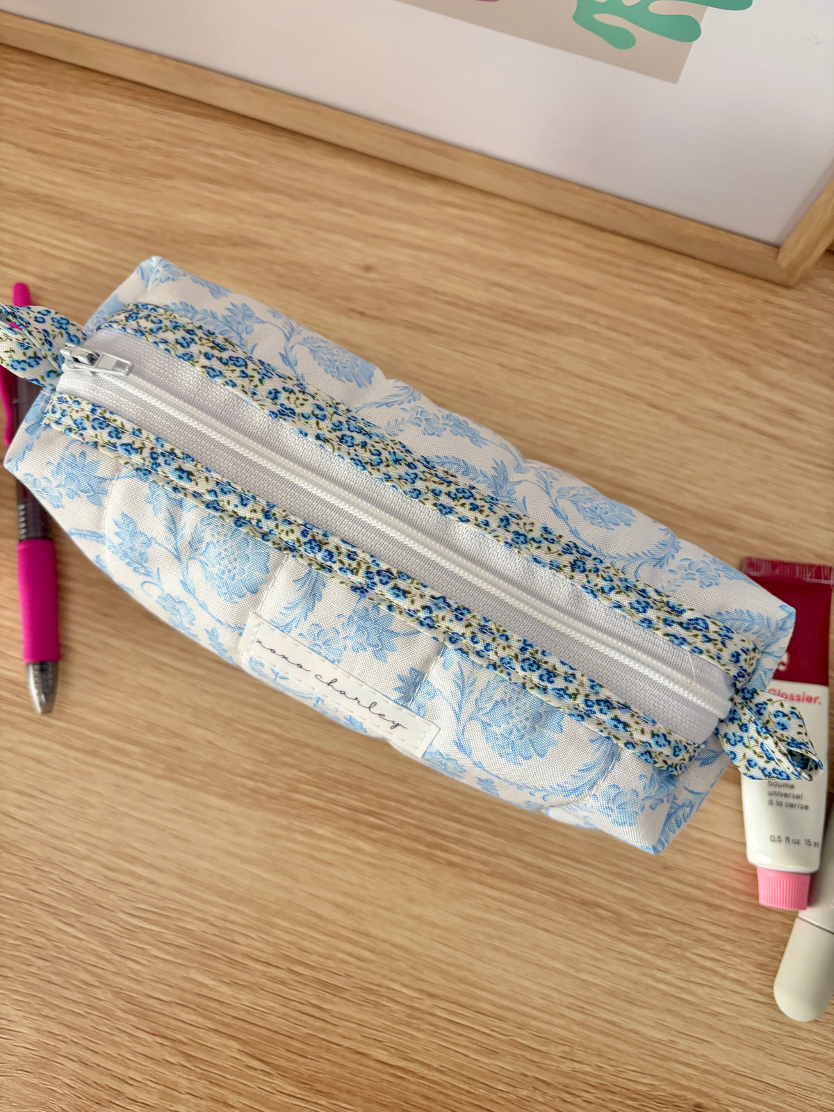 Zippered pouch with light blue floral outer and long top zipper
