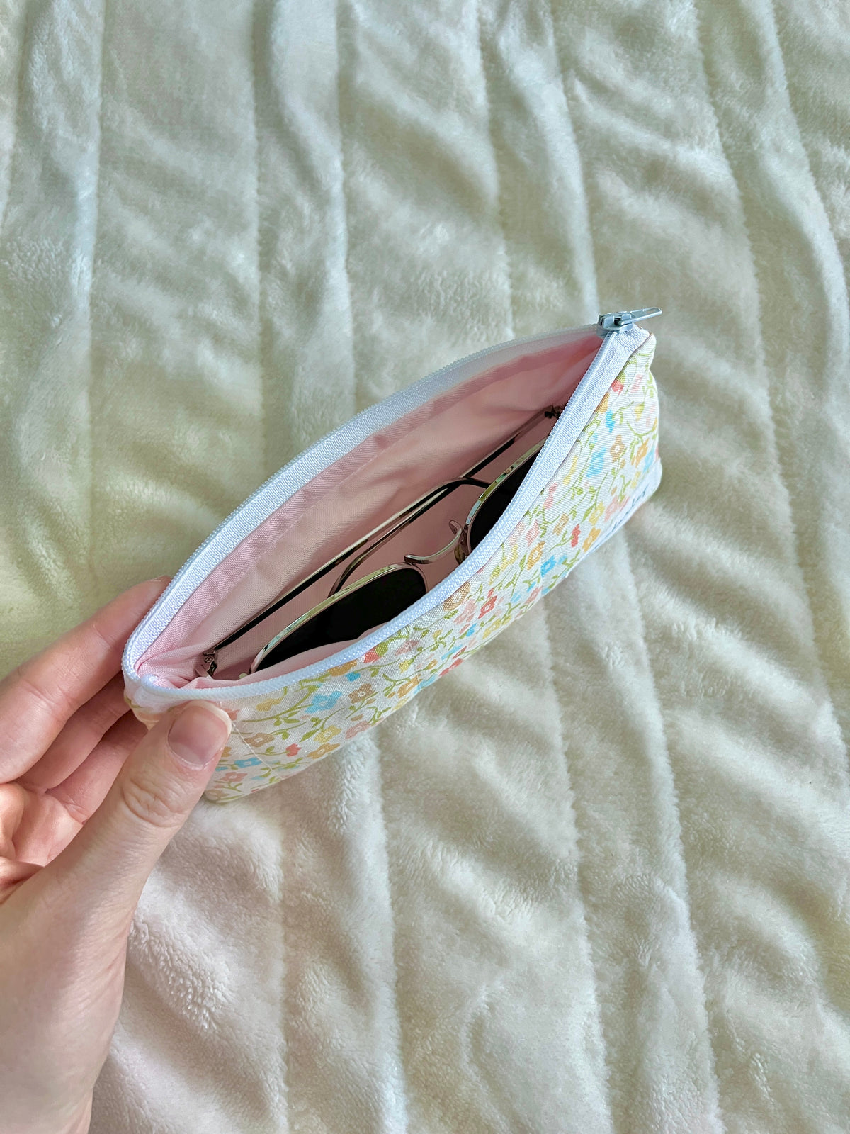 Pencil and glasses case pouch open, pale floral outer with pink interior
