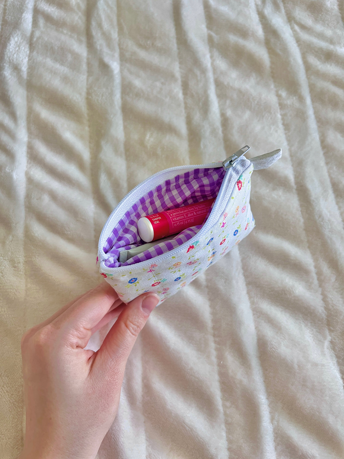 Floral keychain wallet pouch with purple gingham interior, held open