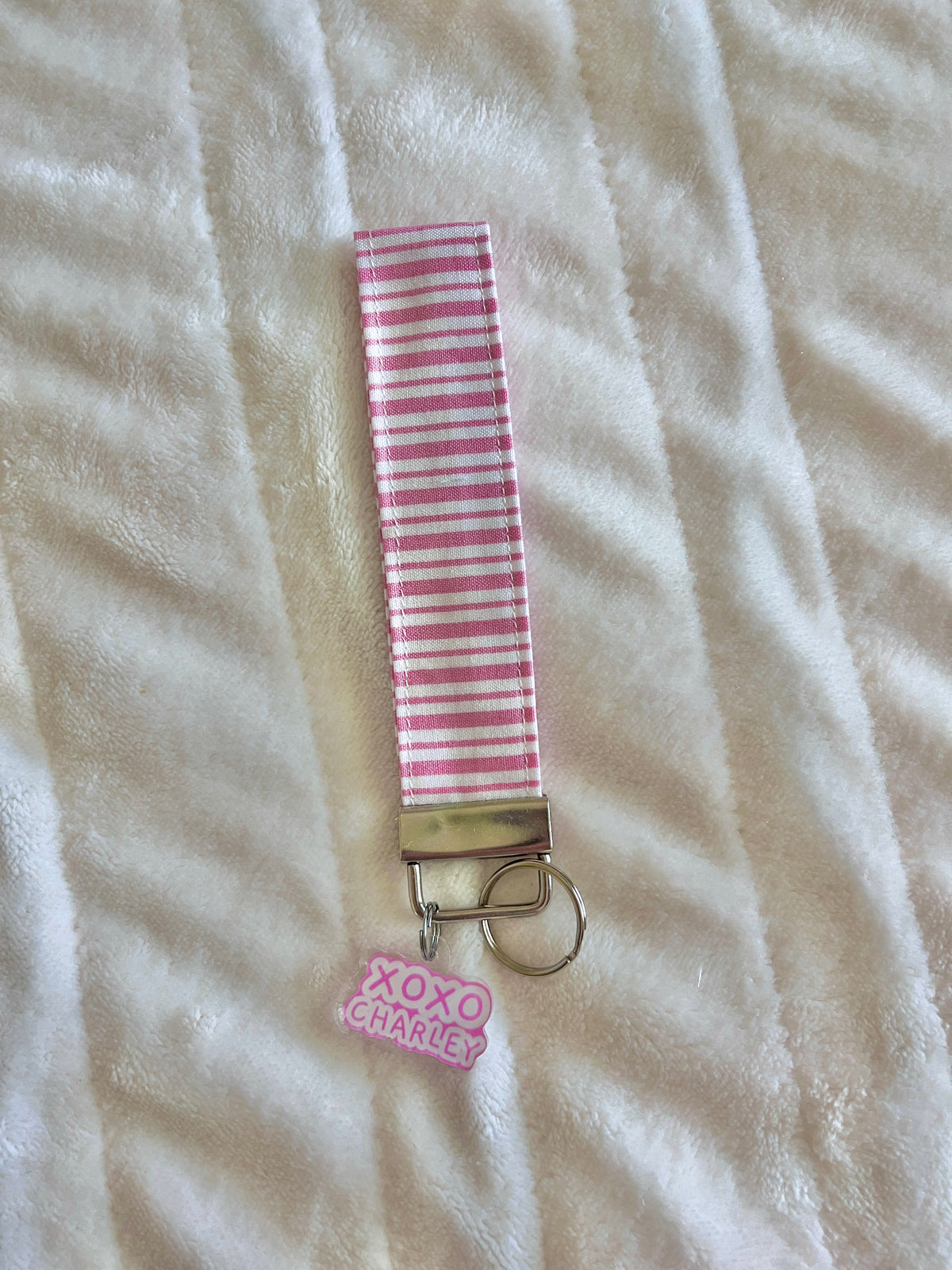 Pink striped wristlet keychain with keyring and XOXO charm on metal clip