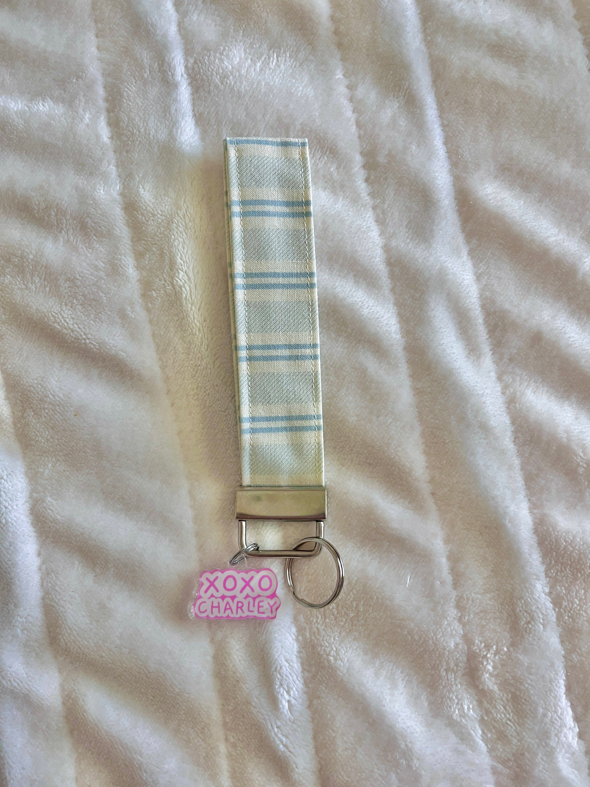 Striped keychain wristlet with metal clasp and XOXO CHARLEY charm
