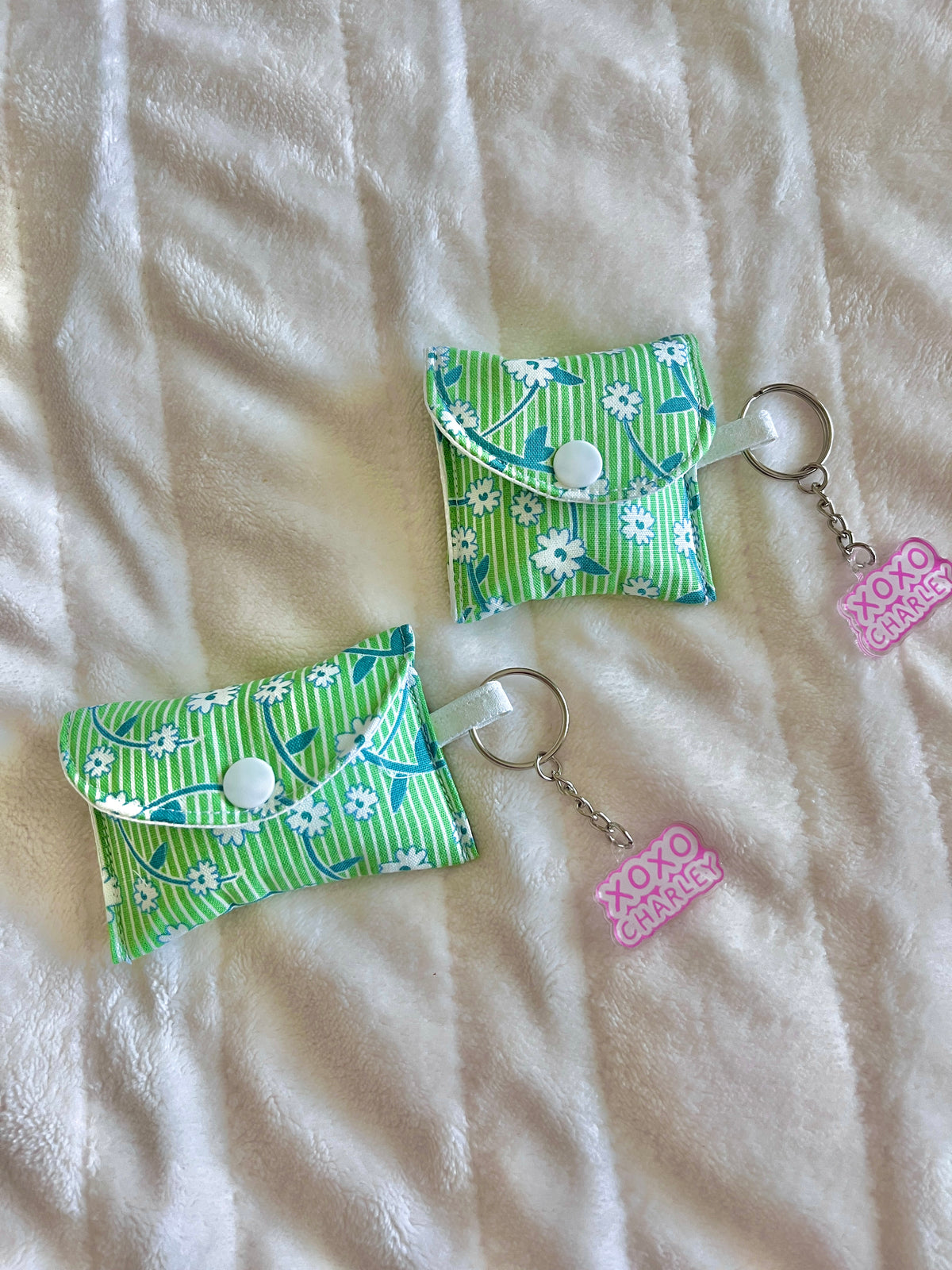 Green floral earbud cases with snap button, fabric holder, and keychain rings