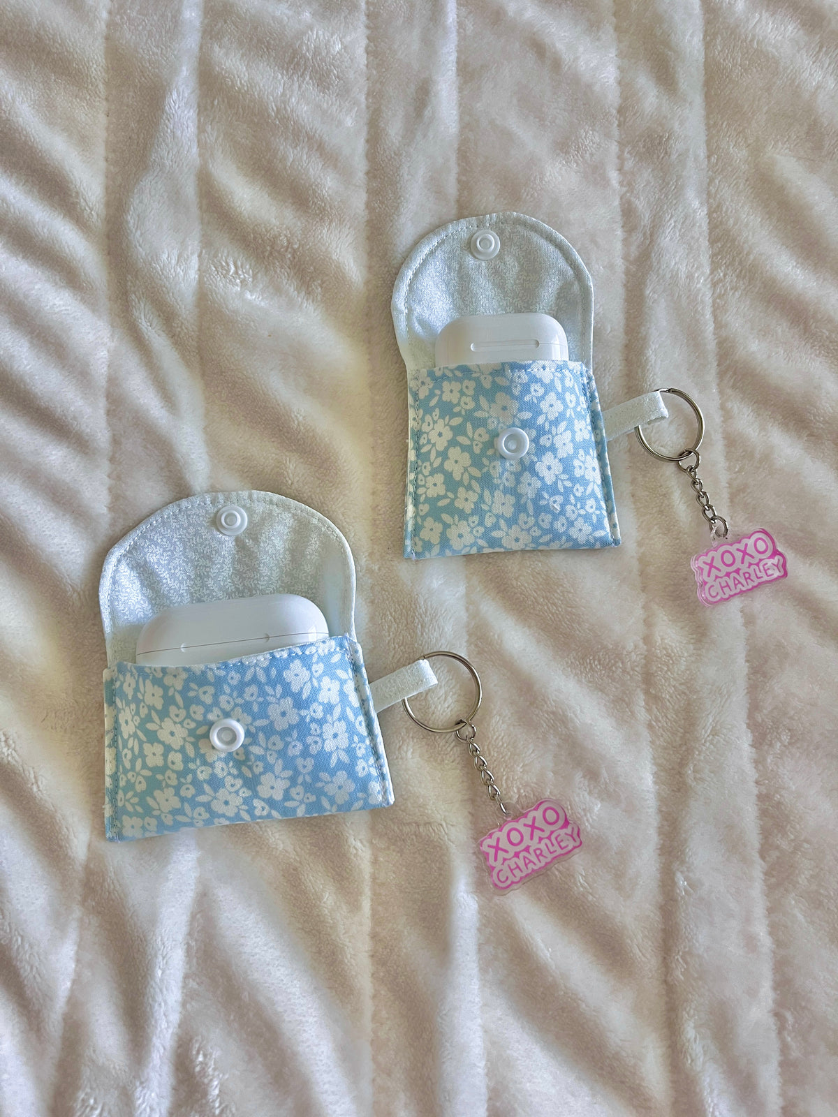 Floral earbud cases with key rings, button closure, and pink XOXO charm