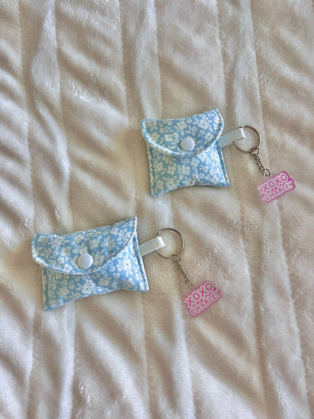 Floral earbud cases with key rings, button closure, and pink XOXO charms