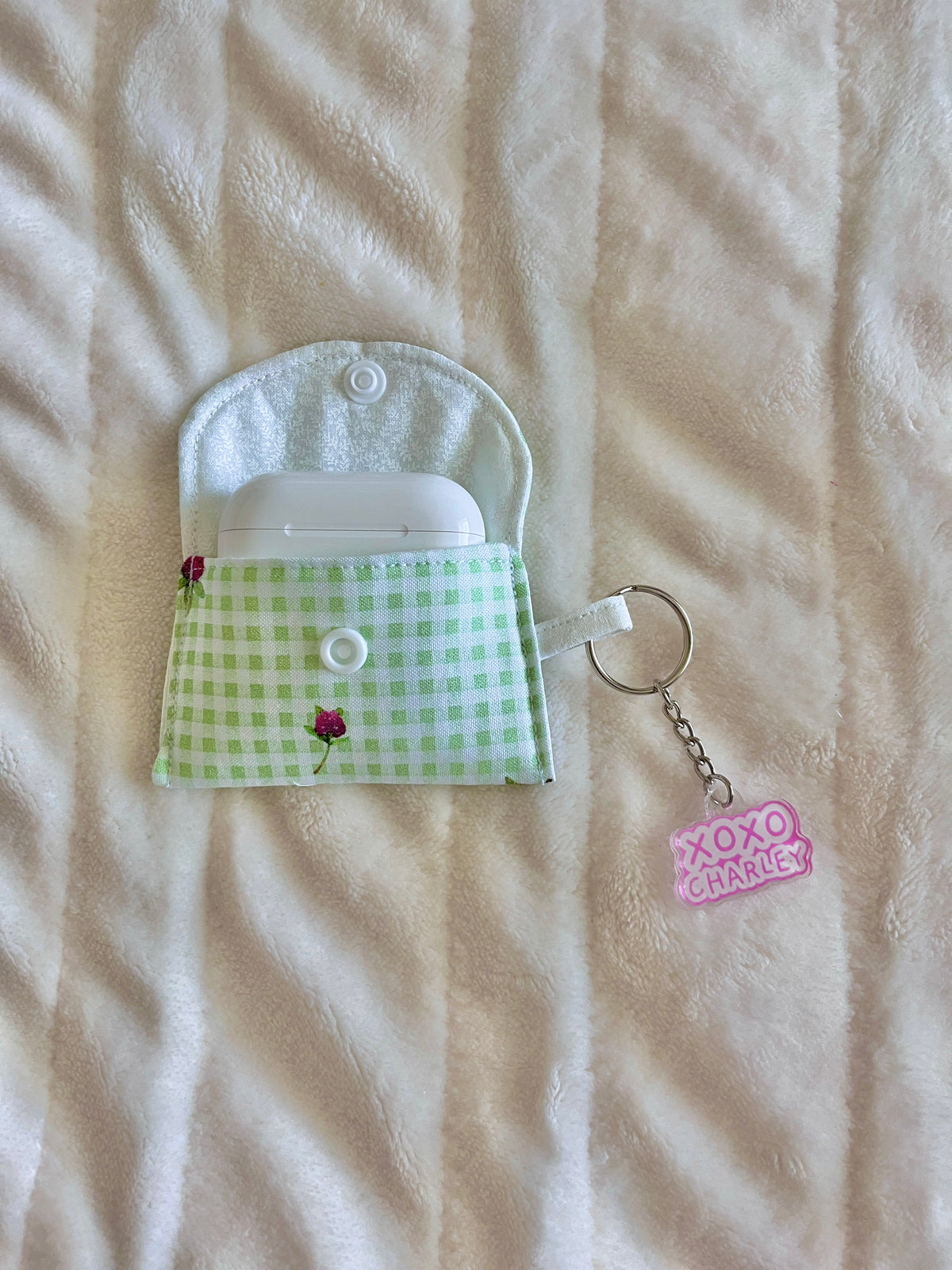 Eden earbuds case open view, green gingham panel with snap button and small keyring