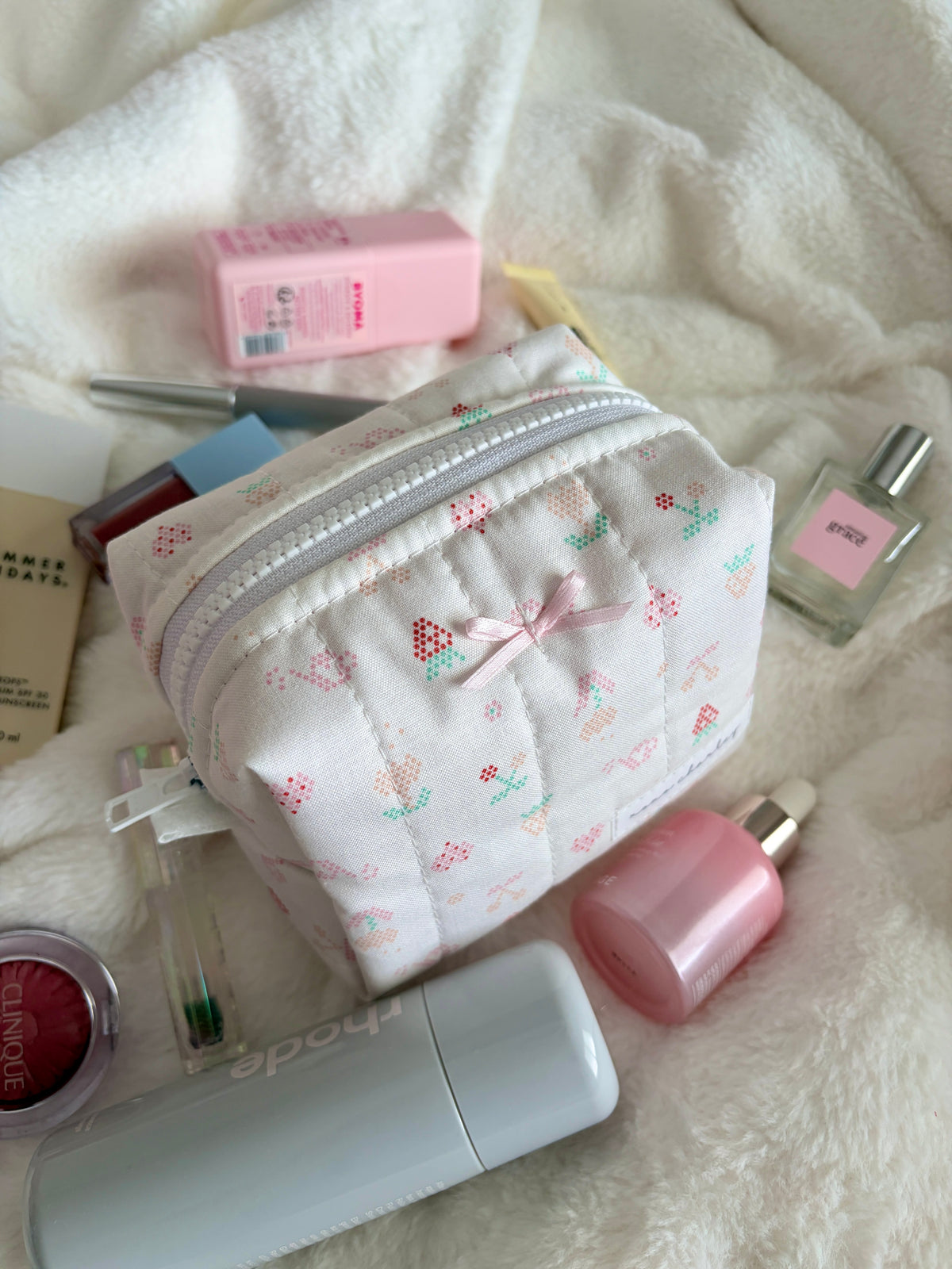 Mini makeup bag with pastel print and zipper, light pink bow detail
