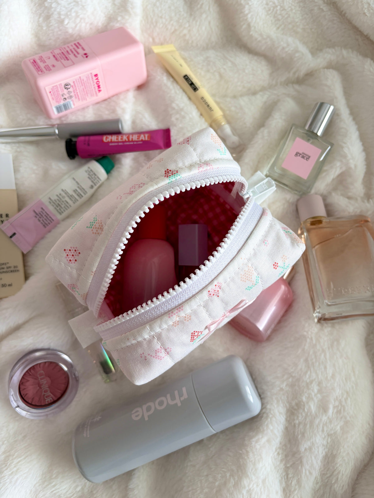 Open mini makeup bag, white fabric with colorful print and silver zipper