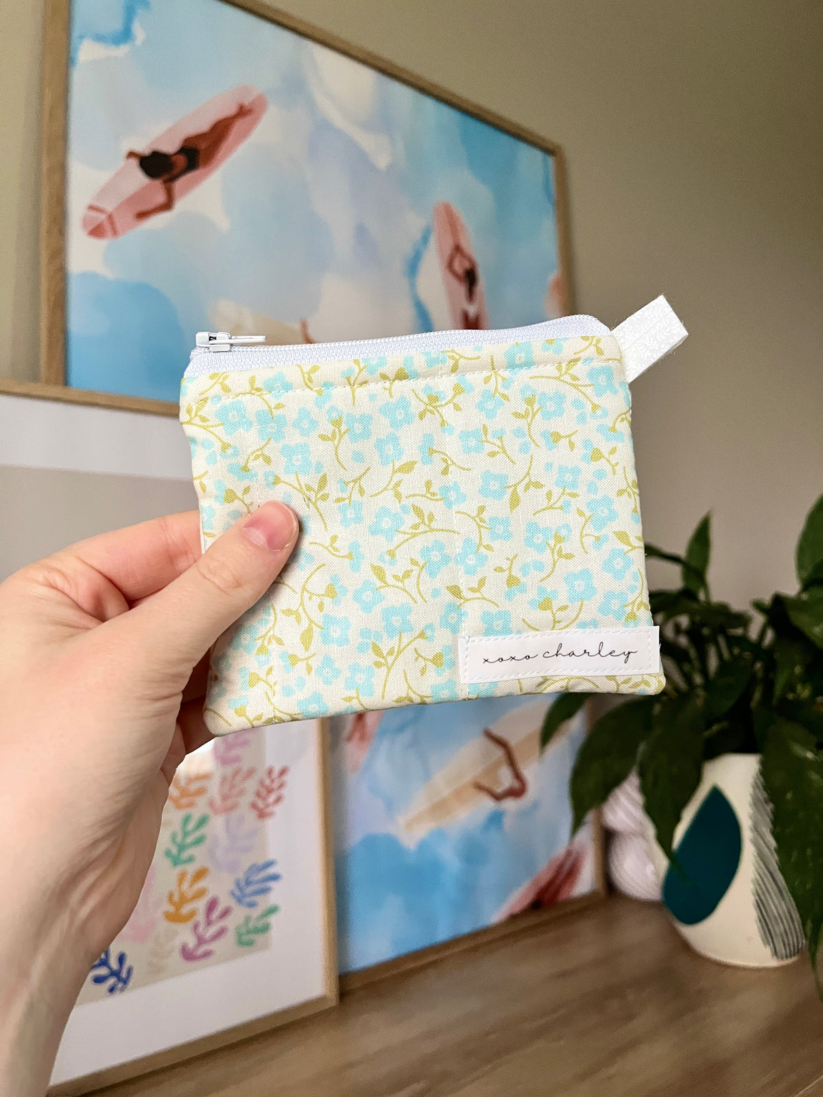 Light blue floral keychain wallet pouch with zipper and fabric tag patch front