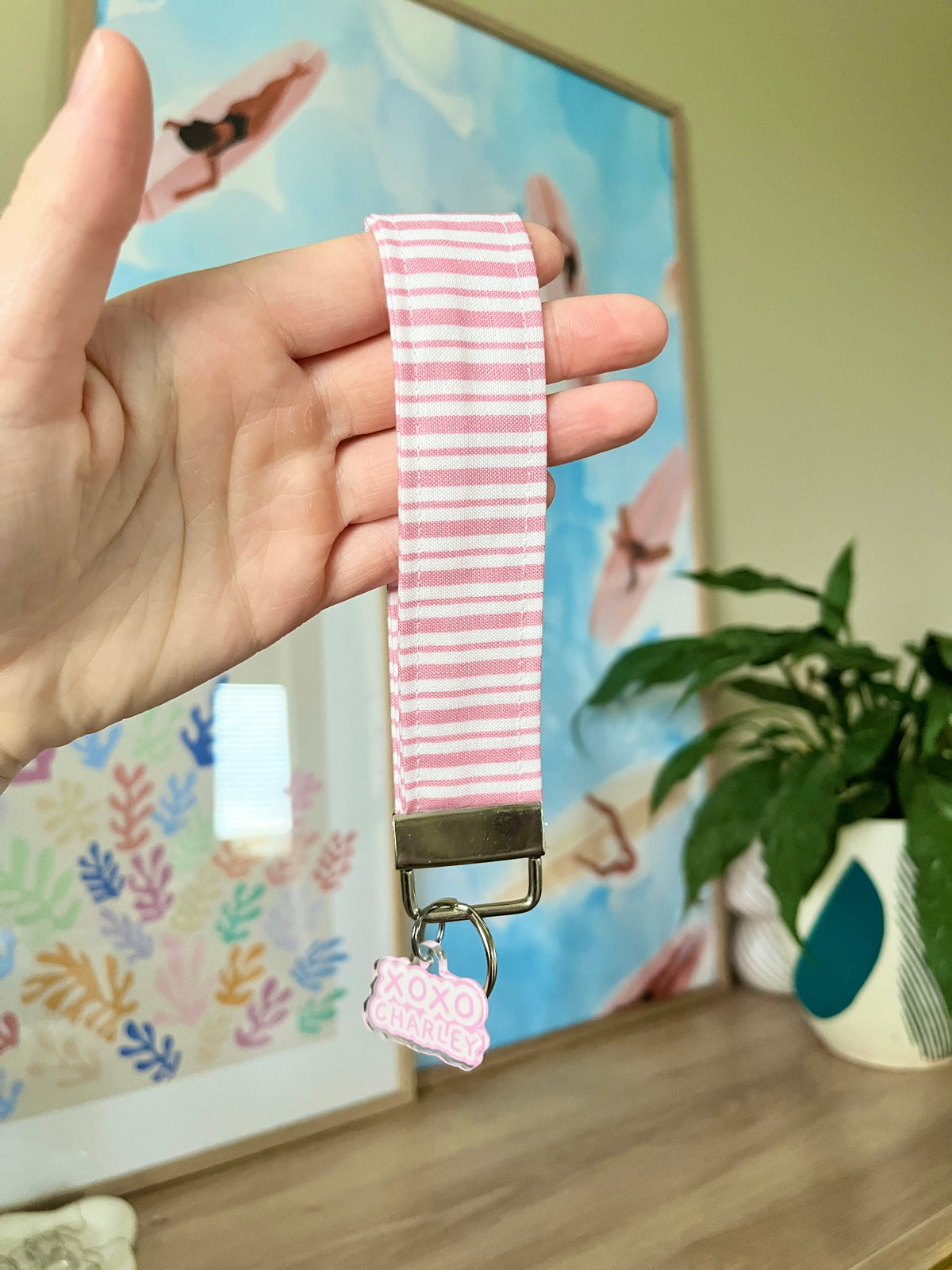 Pink striped wristlet keychain with metal clip and XOXO charm tag