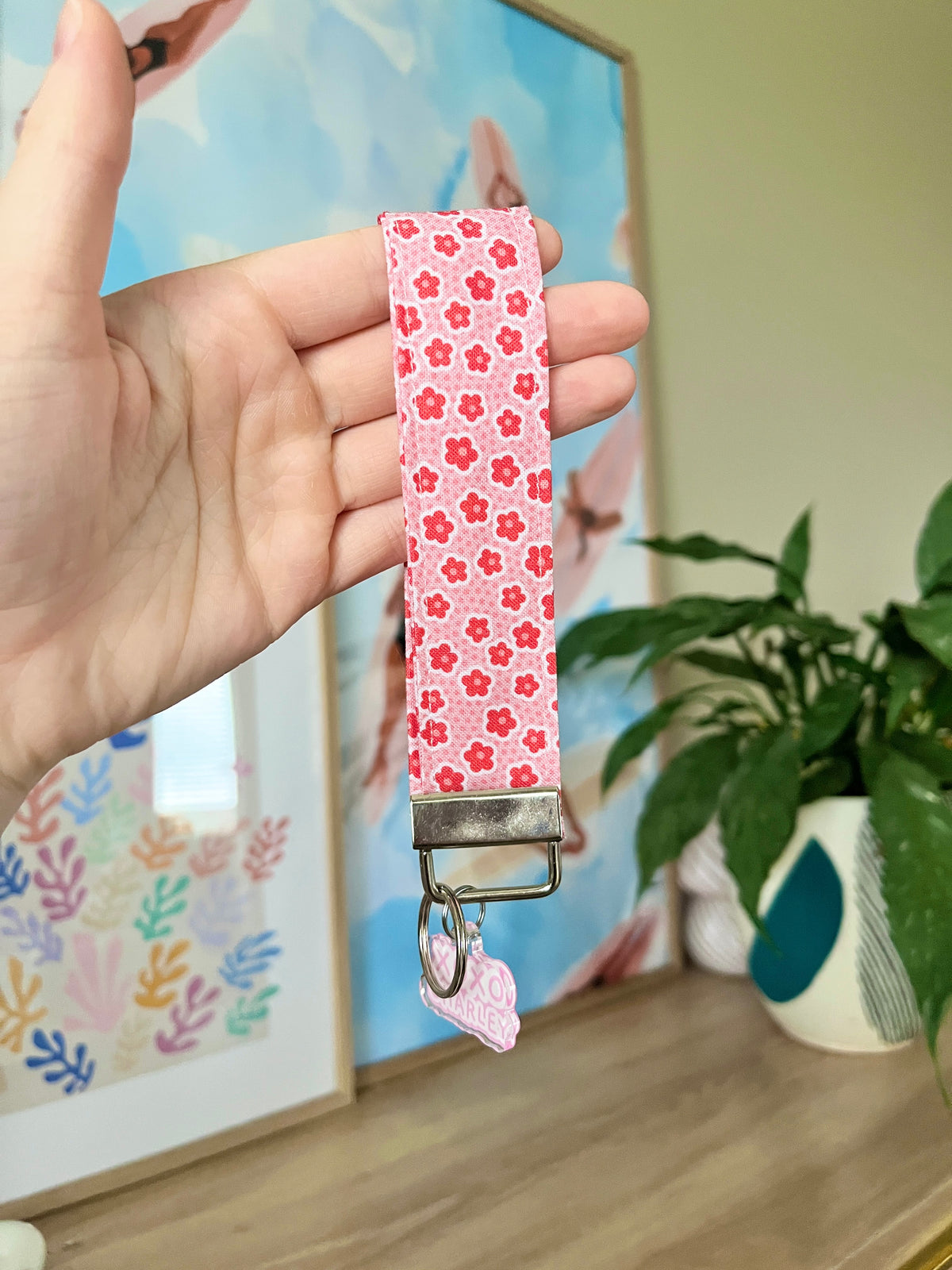 Pink floral keychain wristlet strap with metal buckle and small pink charm loop
