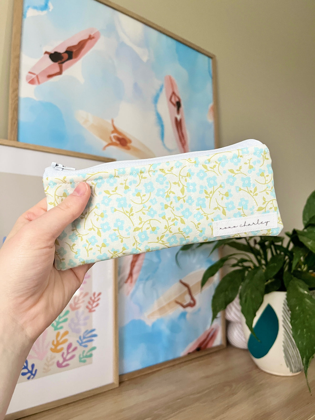 Floral pencil and glasses case pouch held upright, blue-trim zipper