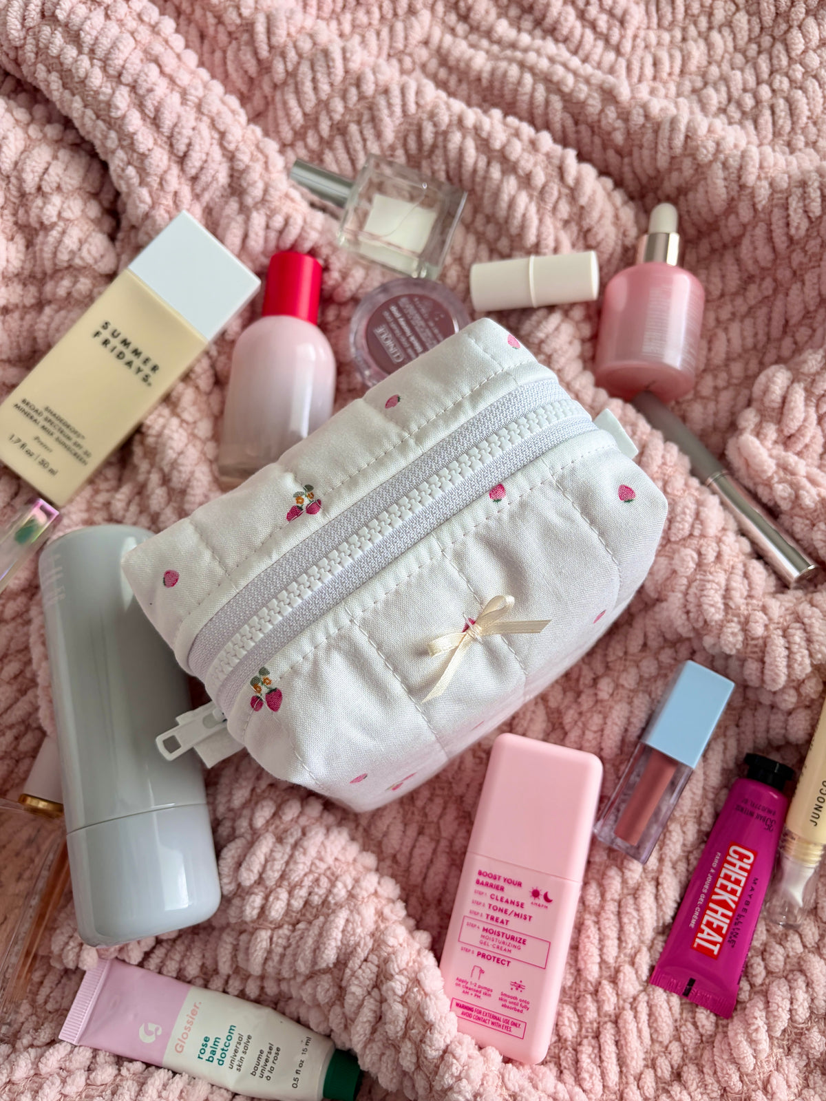 Ivory mini makeup bag with embroidered cherries, bow detail, and white zipper