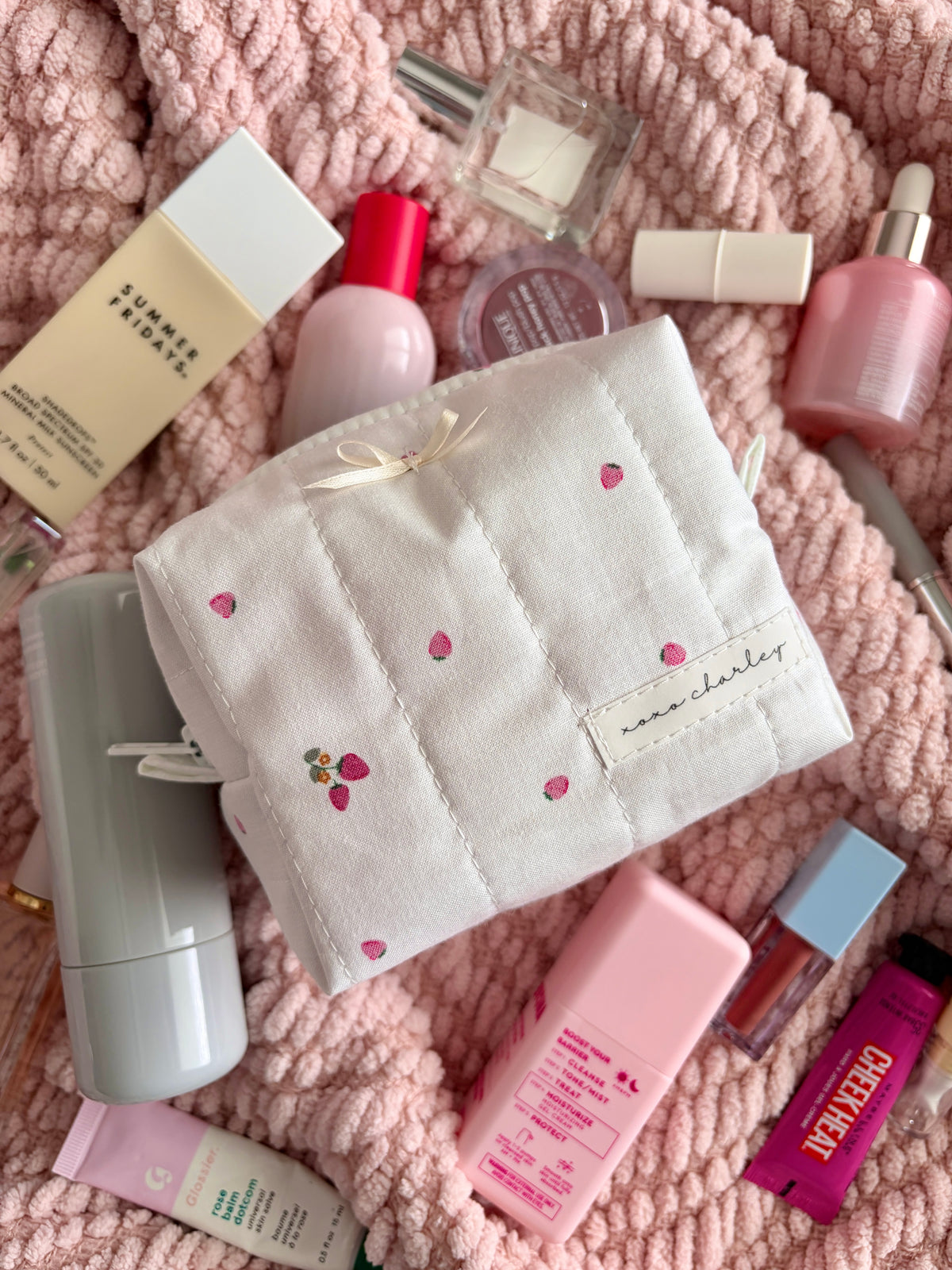 Ivory mini makeup bag with front flap pocket, small bow, and stitched fruit dots